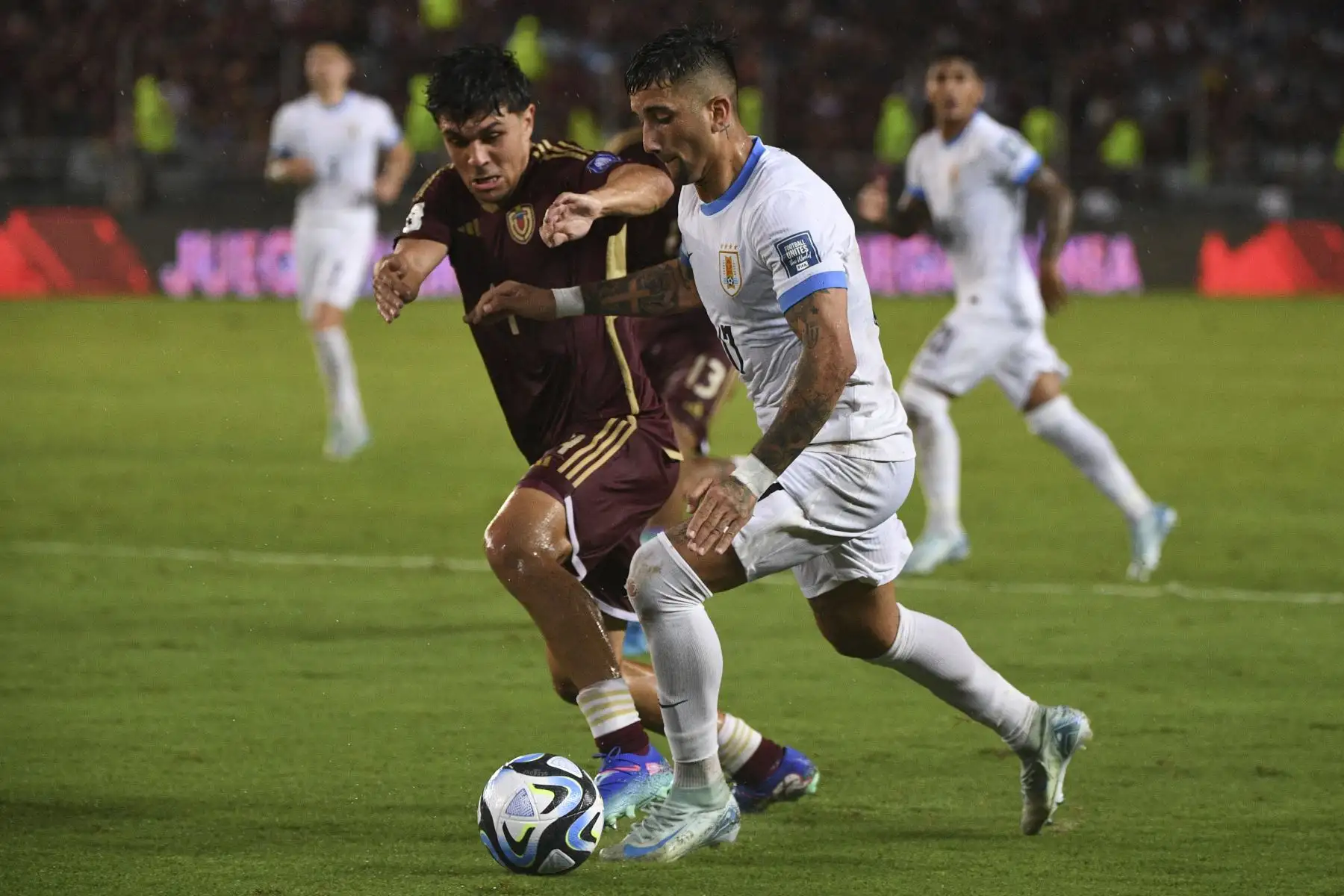El defensor venezolano Jon Aramburu y el delantero uruguayo Cristian Olivera luchan por el balón durante el partido de fútbol de las eliminatorias sudamericanas para la Copa Mundial de la FIFA 2026 entre Venezuela y Uruguay en el estadio Monumental de Maturín, Venezuela.
Foto: AFP