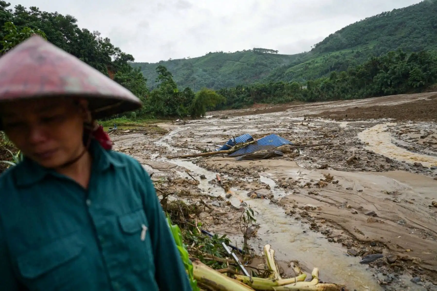 Un residente se encuentra cerca de los escombros después de que un deslizamiento de tierra envolviera la aldea de Lang Nu, en la provincia de Lao Cai. Foto: AFP