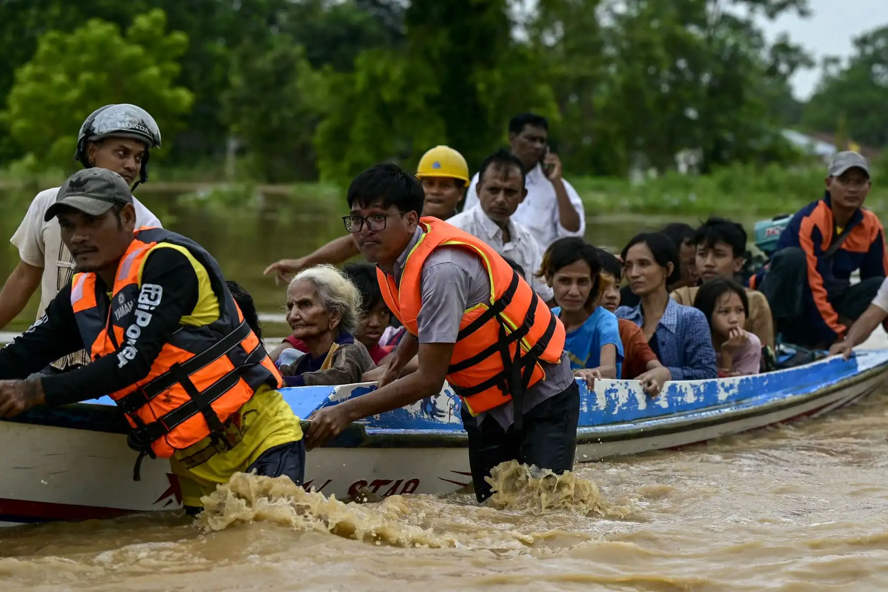 Los residentes afectados por las inundaciones son transportados en un barco de rescate en Taungoo, región de Bago, Myanmar, el 14 de septiembre de 2024, tras las fuertes lluvias provocadas por el tifón Yagi. El tifón Yagi provocó un diluvio colosal que inundó una franja del norte de Vietnam. Foto: ANDINA/AFP