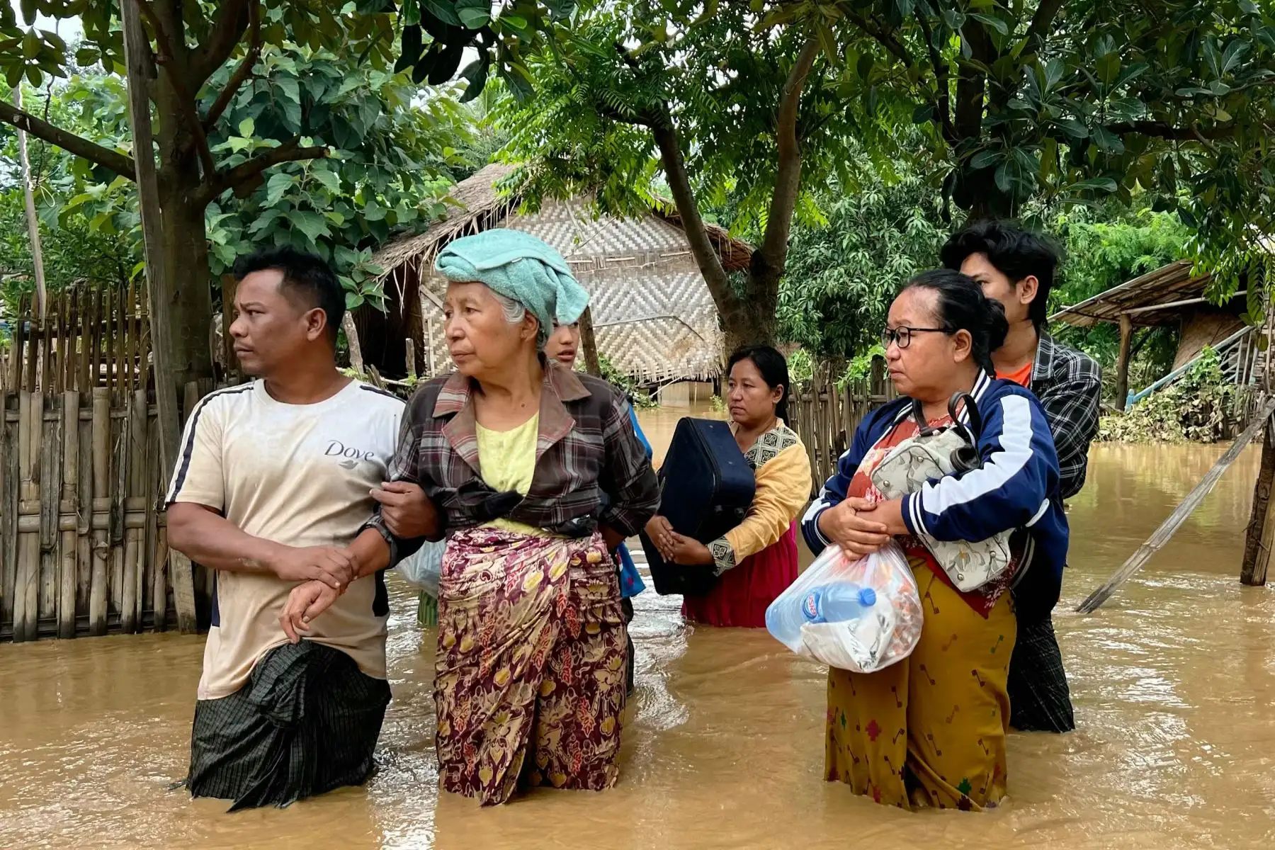 Los residentes se encuentran bajo las aguas de la inundación con sus pertenencias en la aldea de Sin Thay en Pyinmana, en la región de Naypyidaw de Myanmar, el 14 de septiembre de 2024, tras las fuertes lluvias provocadas por el tifón Yagi. El tifón Yagi provocó un diluvio colosal que inundó una franja del norte de Vietnam. Foto: ANDINA/ AFP