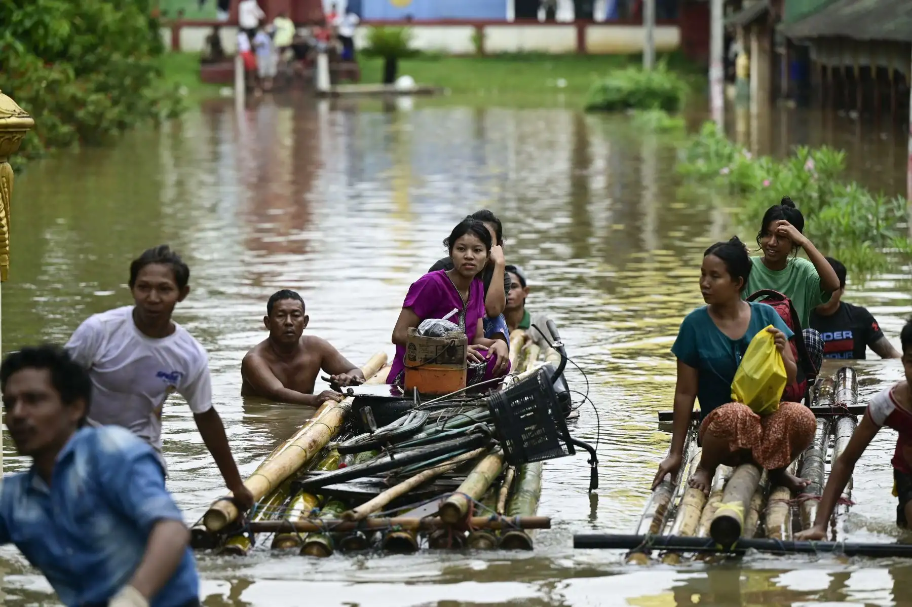 Los residentes afectados por las inundaciones utilizan balsas de bambú para desplazarse a terrenos más altos en Taungoo, región de Bago, Myanmar, el 14 de septiembre de 2024, tras las fuertes lluvias que siguieron al paso del tifón Yagi. El tifón Yagi provocó un diluvio colosal que inundó una franja del norte de Vietnam. Foto. ANDINA/AFP
