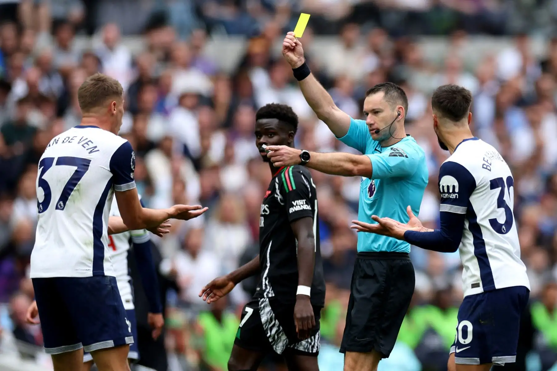 El árbitro australiano Jarred Gillett muestra una tarjeta amarilla al defensor holandés  del Tottenham Hotspur, Micky van de Ven, durante el partido de fútbol de la Premier League inglesa entre el Tottenham Hotspur y el Arsenal en el Tottenham Hotspur Stadium en Londres. 
Foto. ANDINA/AFP