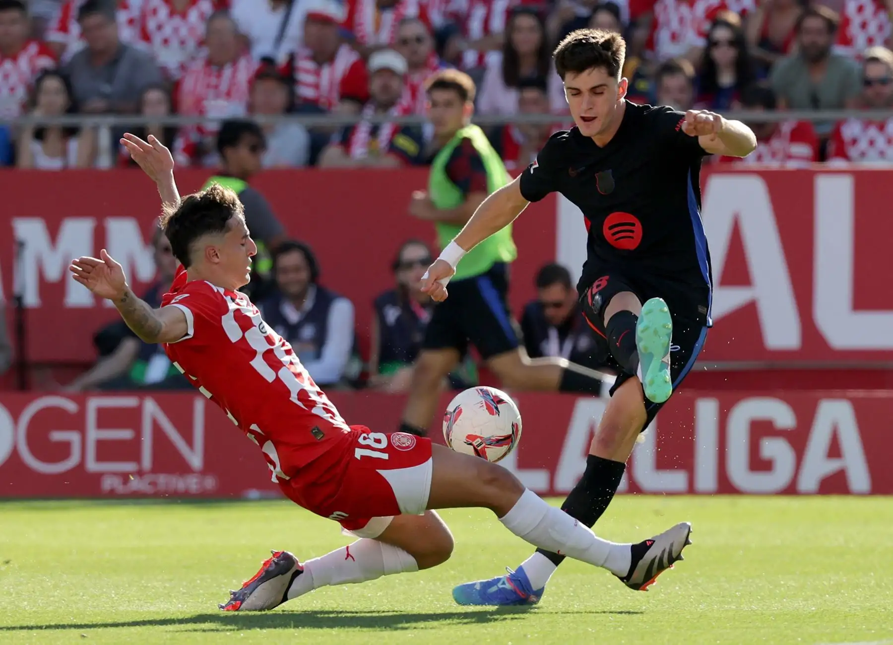 El defensa español del Girona, Alejandro Frances, lucha por el balón con el delantero español del Barcelona, ​​Pau Victor Delgado, durante el partido de fútbol de la liga española entre el Girona FC y el FC Barcelona.  Foto. ANDINA/AFP