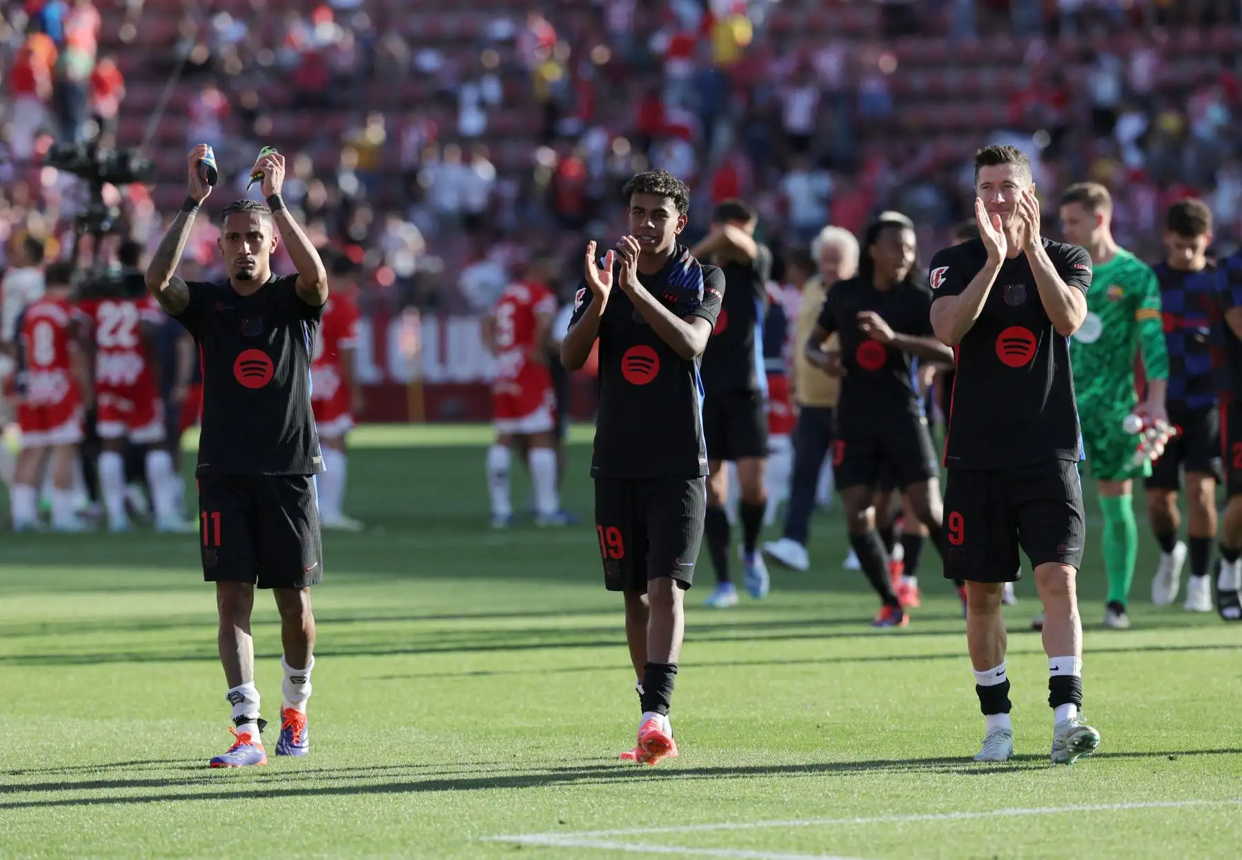 El delantero brasileño del Barcelona, ​​Raphinha, el delantero español del Barcelona, ​​Lamine Yamal, y el delantero polaco del Barcelona, ​​Robert Lewandowski, aplauden al final del partido de fútbol de la liga española entre el Girona FC y el FC Barcelona. 
Foto: ANDINA/AFP