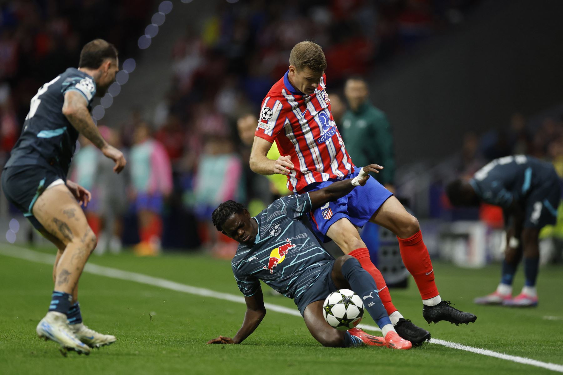 El delantero noruego del Atlético de Madrid, Alexander Sorloth, cae sobre el defensa francés del RB Leipzig, Castello Lukeba, durante el partido de fútbol de primera ronda de la Liga de Campeones de la UEFA entre el Club Atlético de Madrid y el RB Leipzig en el estadio Metropolitano de Madrid. Foto: AFP