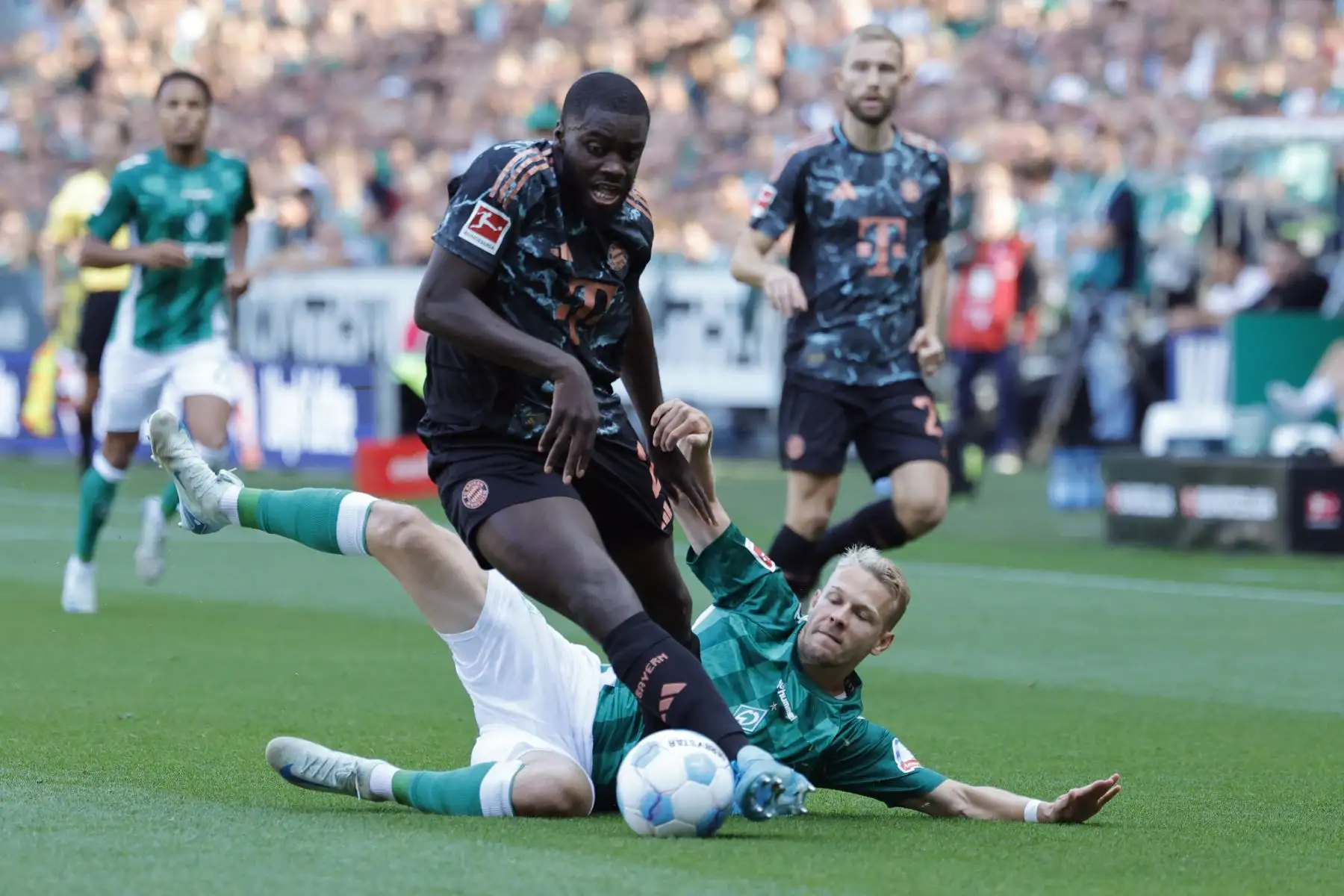 El defensa francés del Bayern Munich Dayot Upamecano y el delantero austríaco del Bremen Marco Gruell compiten por el balón durante el partido de fútbol de la primera división alemana Bundesliga entre SV Werder Bremen y FC Bayern Munich en Bremen, norte de Alemania. Foto: ANDINA/ AFP