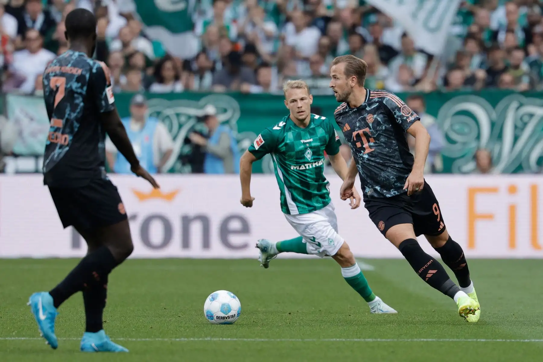 El delantero inglés del Bayern Munich Harry Kane y el delantero austríaco del Bremen Marco Gruell compiten por el balón durante el partido de fútbol de la primera división alemana Bundesliga entre SV Werder Bremen y FC Bayern Munich en Bremen, norte de Alemania. Foto: ANDINA/AFP