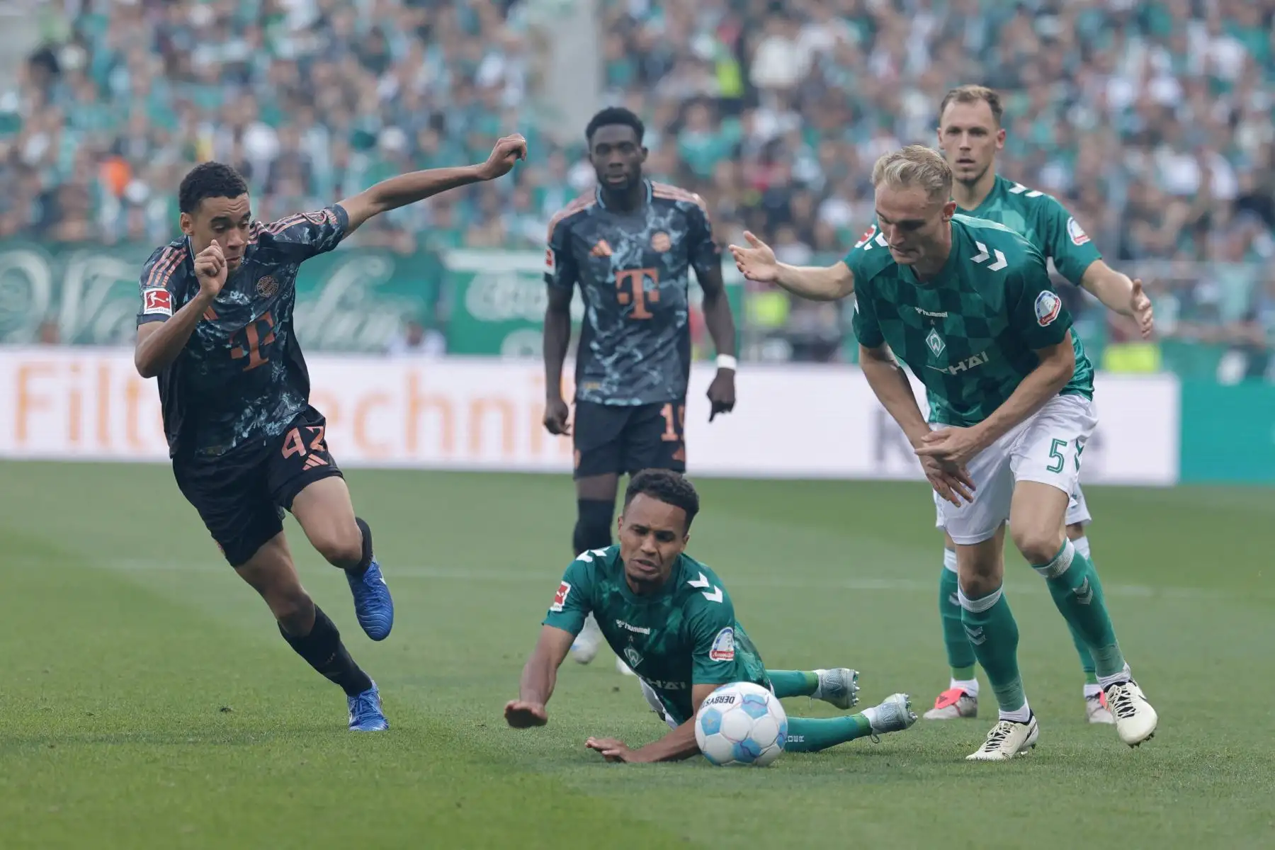 El centrocampista alemán del Bayern Munich Jamal Musiala, el defensa alemán del Bremen Felix Agu y el defensa alemán del Bremen Amos Pieper compiten por el balón durante el partido de fútbol de la primera división alemana Bundesliga entre SV Werder Bremen y FC Bayern Munich en Bremen, norte de Alemania.  Foto: ANDINA/AFP