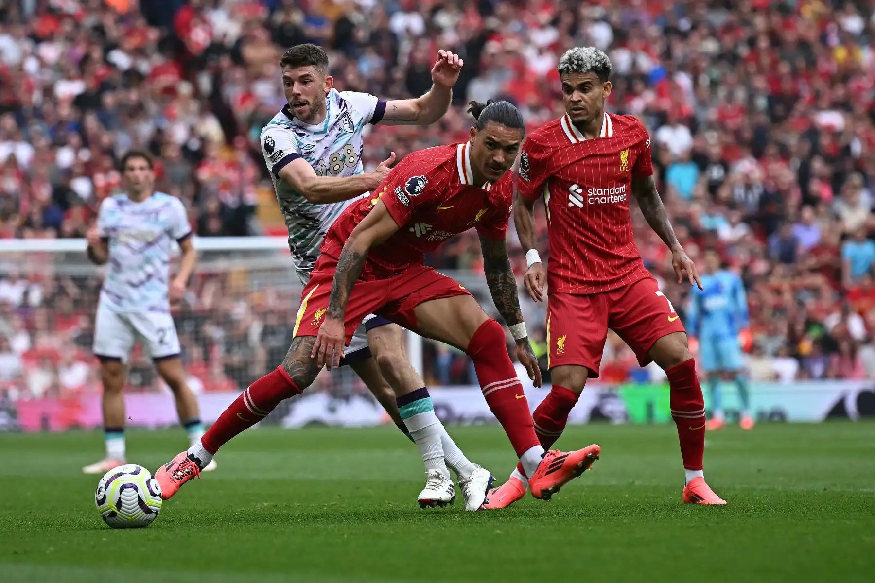 El delantero uruguayo del Liverpool Darwin Núñez y el mediocampista colombiano del Liverpool Luis Díaz desafían al mediocampista escocés del Bournemouth Ryan Christie durante el partido de fútbol de la Liga Premier inglesa entre Liverpool y Bournemouth en Anfield en Liverpool, noroeste de Inglaterra.Foto. ANDINA/AFP)