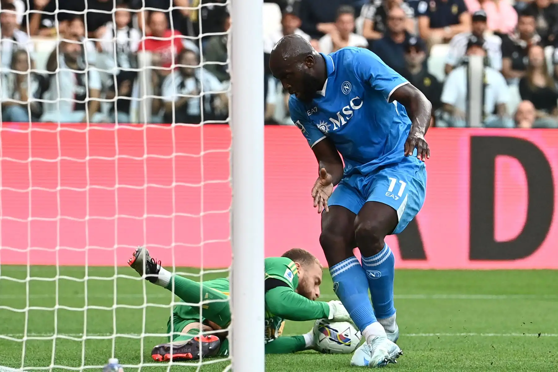 El portero italiano de la Juventus, Michele Di Gregorio, detiene el balón ante el delantero belga del Napoli, Romelu Lukaku, durante un partido de la Serie A italiana entre la Juventus y el Napoli en el estadio Allianz de Turín. Foto: ANDINA/AFP