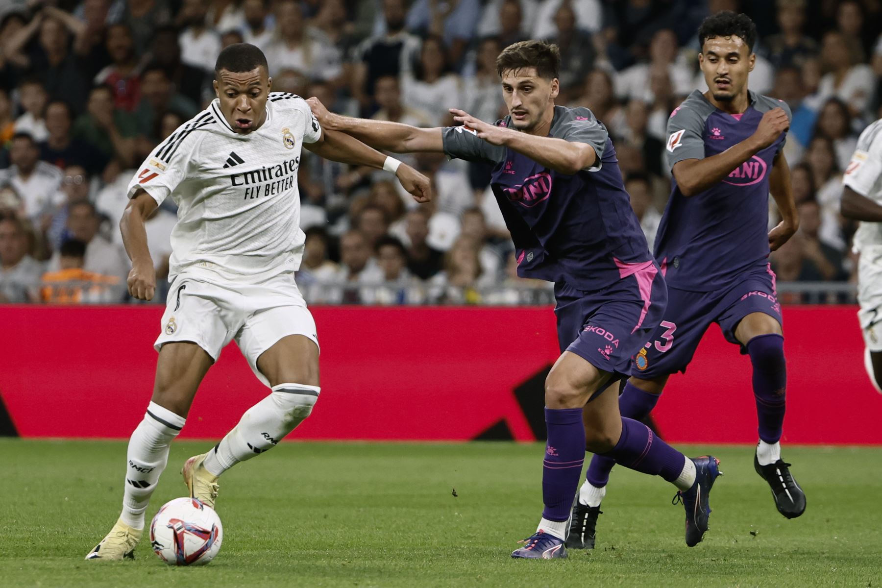 El delantero francés del Real Madrid, Kylian Mbappé, con el balón ante el defensa albanés del Espanyol, Marash Kumbulla, durante el encuentro correspondiente a la sexta jornada de Laliga EA Sports que disputan hoy sábado Real Madrid y Espanyol en el estadio Santiago Bernábeu.
Foto: EFE