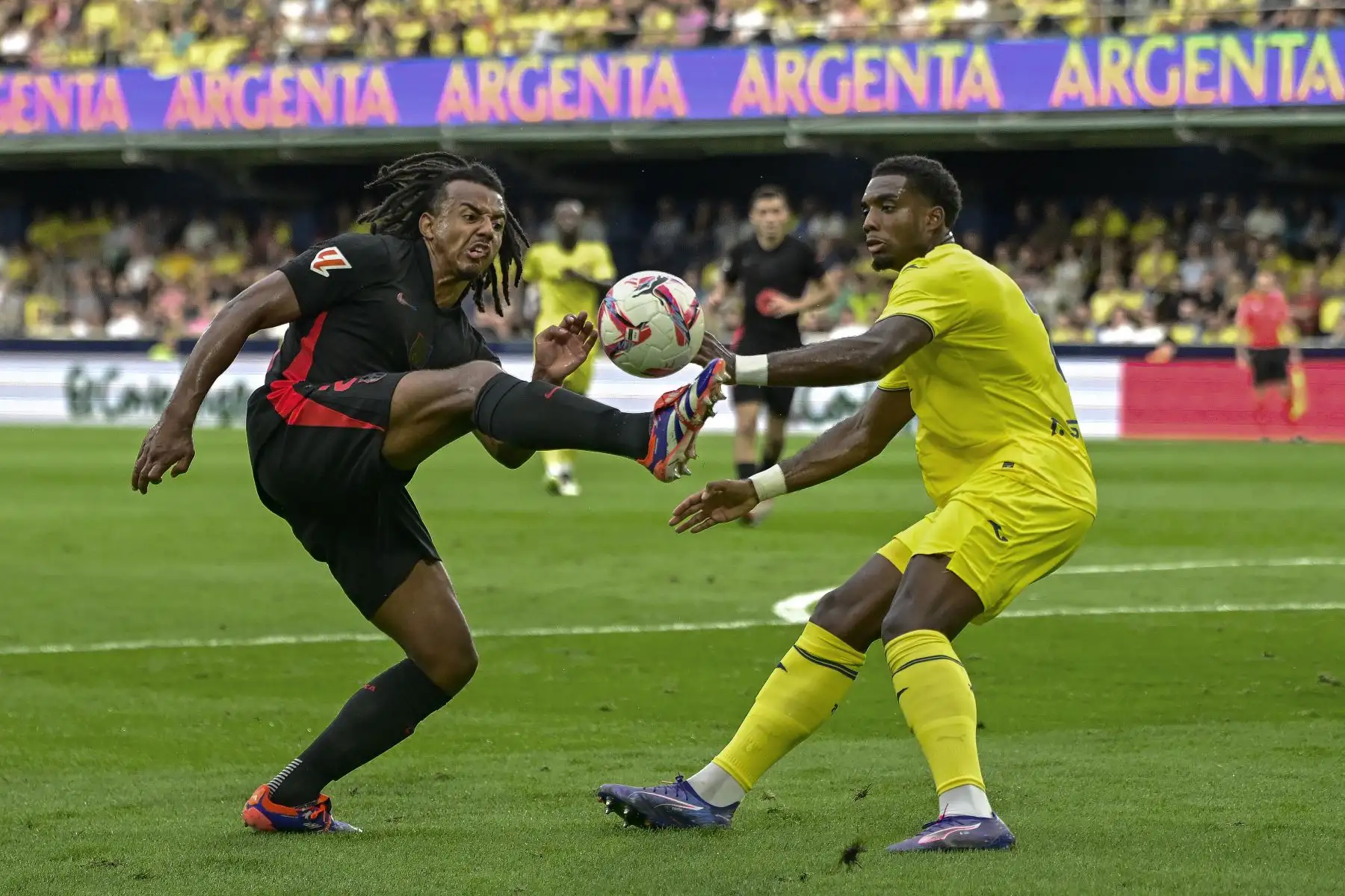 El defensa francés del FC Barcelona, Jules Koundé, disputa el balón ante el defensa caboverdiano del Villarreal, Logan Costa, durante el encuentro correspondiente a la sexta jornada de Laliga EA Sports que disputan hoy Domingo FC Barcelona y Villarreal en el estadio de La Cerámica. 
Foto: ANDINA/EFE
