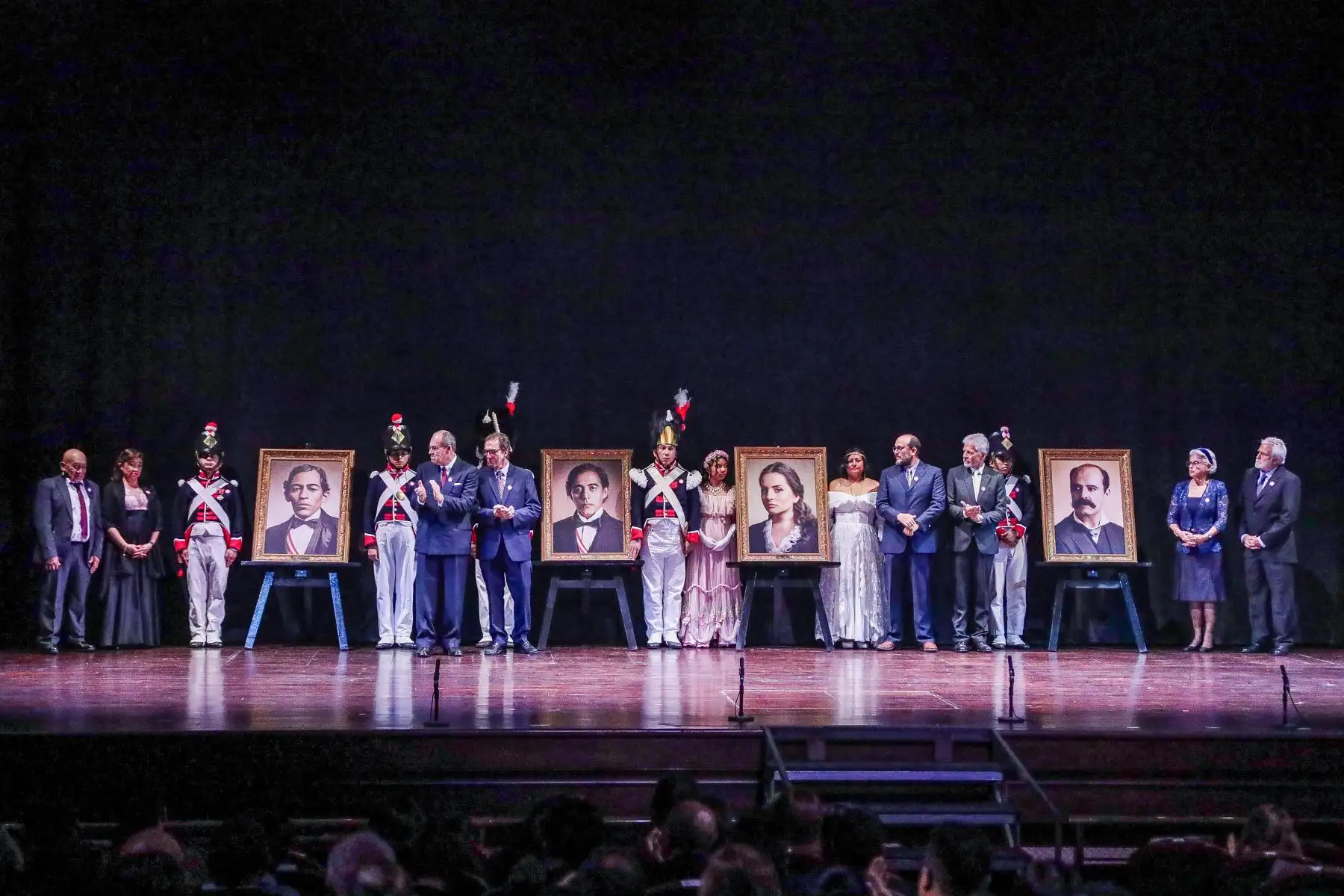 Descendientes de los ilustres personajes en homenaje posan junto a los retratos de los mismos durante el Concierto de Gala por los 203 años del "Himno Nacional del Perú" en el Teatro Segura. Foto: ANDINA/Connie Calderón