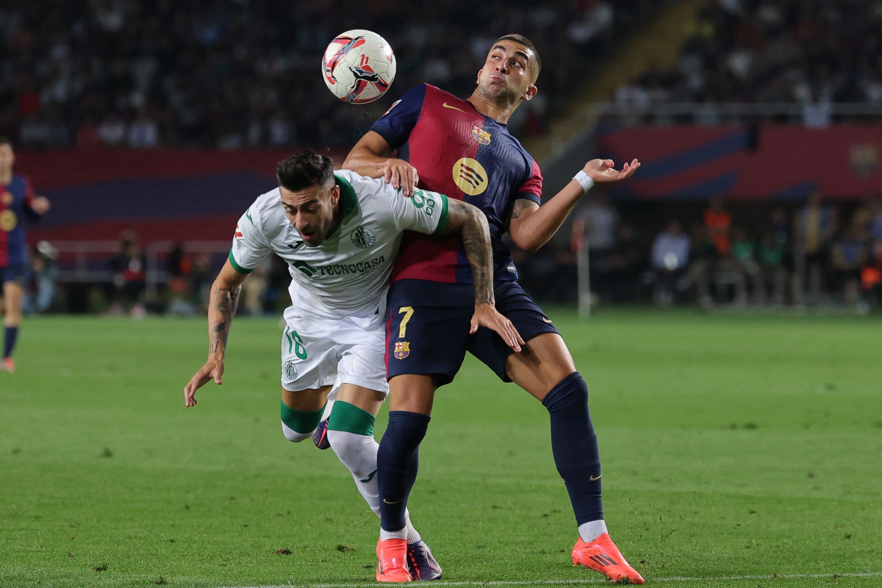 El defensor español del Getafe, Diego Rico, lucha por el balón con el delantero español del Barcelona, Ferran Torres, durante el partido de fútbol de la liga española entre el FC Barcelona y el Getafe CF en el Estadio Olímpico Lluis Companys de Barcelona el 25 de septiembre de 2024. Foto: AFP