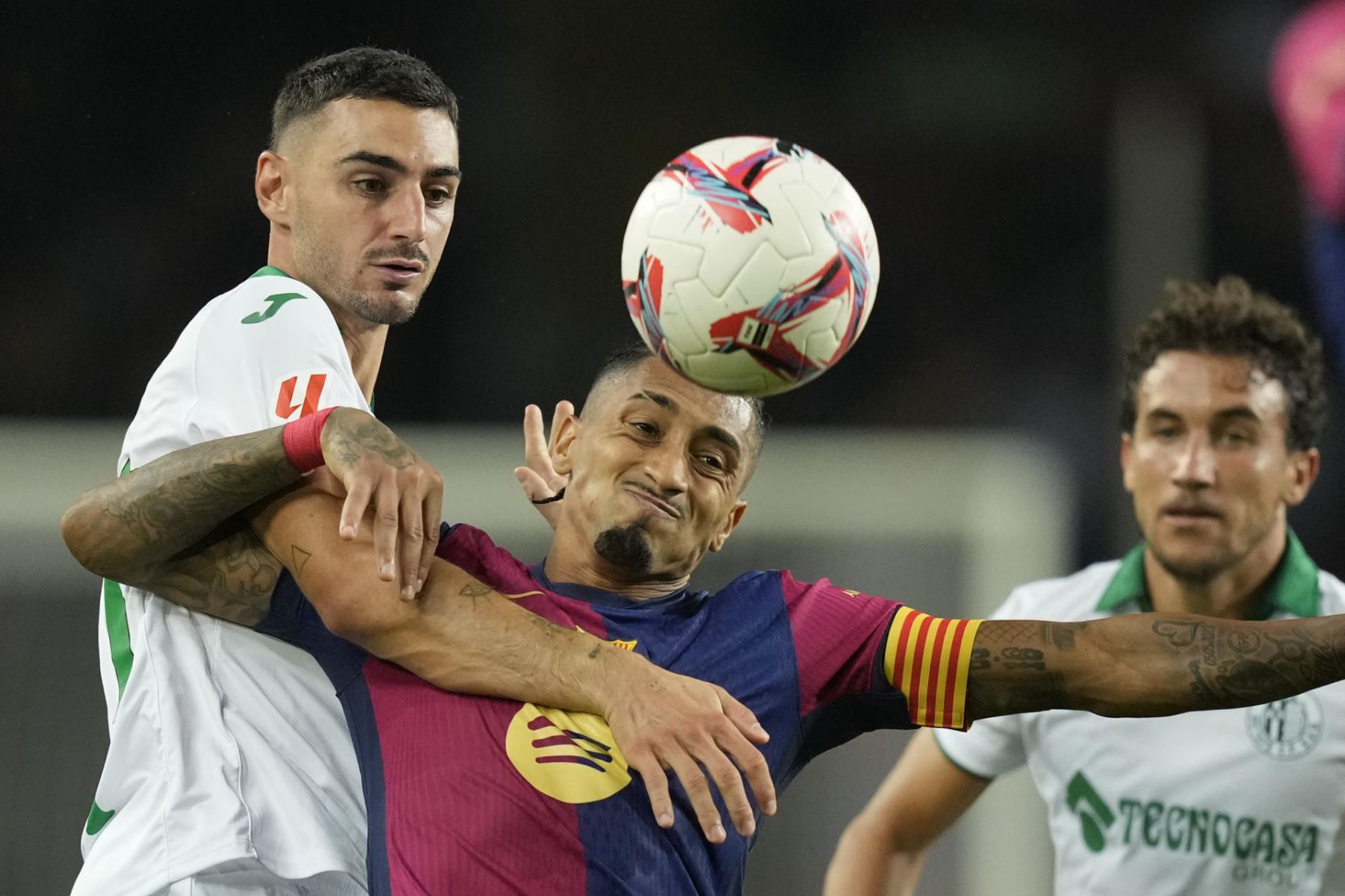 El delantero del FC Barcelona Raphinha lucha con Juan Antonio Iglesias del Getafe durante el encuentro correspondiente a la séptima jornada de La Liga EA Sports que disputan FC Barcelona y Getafe CF, este miércoles en el Estadio Olímpico Lluis Companys, en Barcelona. Foto: EFE