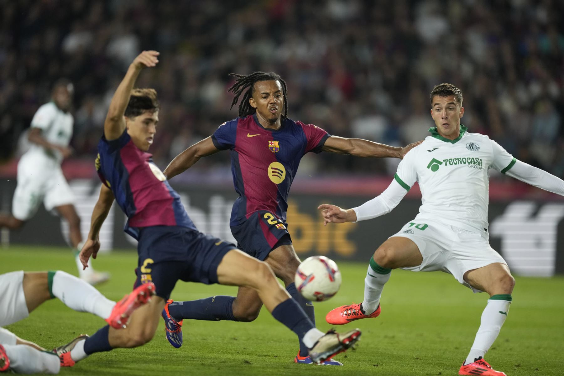 El jugador del Getafe Bertug Yildirim pelea el balón con Jules Koundé y Pau Cubarsi, ambos del Barcelona, durante el partido de la séptima jornada de La Liga EA Sports, que FC Barcelona y Getafe CF disputan este miércoles en el Estadio Olímpico Lluis Companys. Foto: EFE