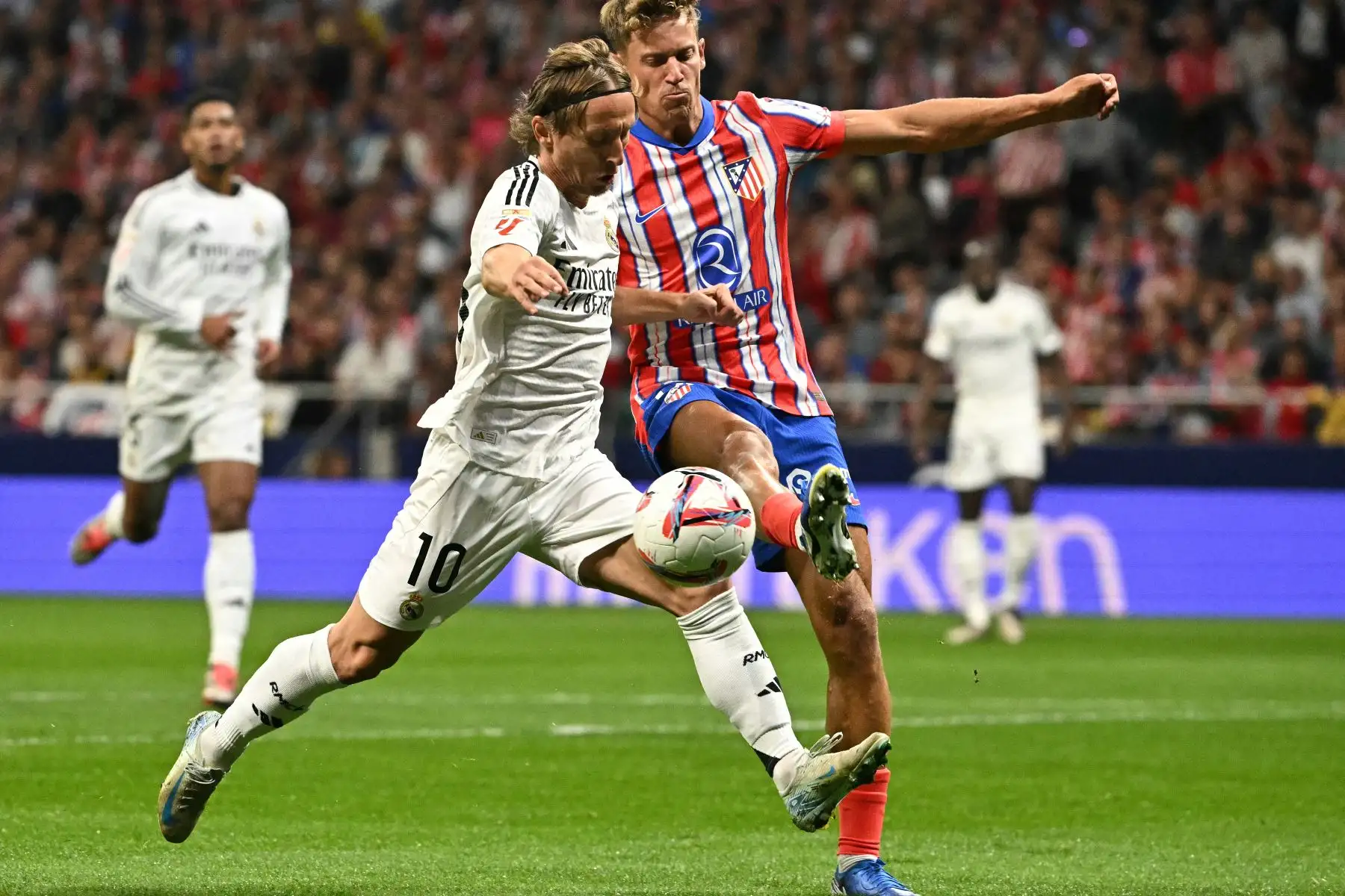El mediocampista croata del Real Madrid,  Luka Modric y el mediocampista español del Atlético de Madrid , Marcos Llorente luchan por el balón durante el partido de fútbol de la liga española entre el Club Atlético de Madrid y el Real Madrid CF en el estadio Metropolitano.
Foto: AFP