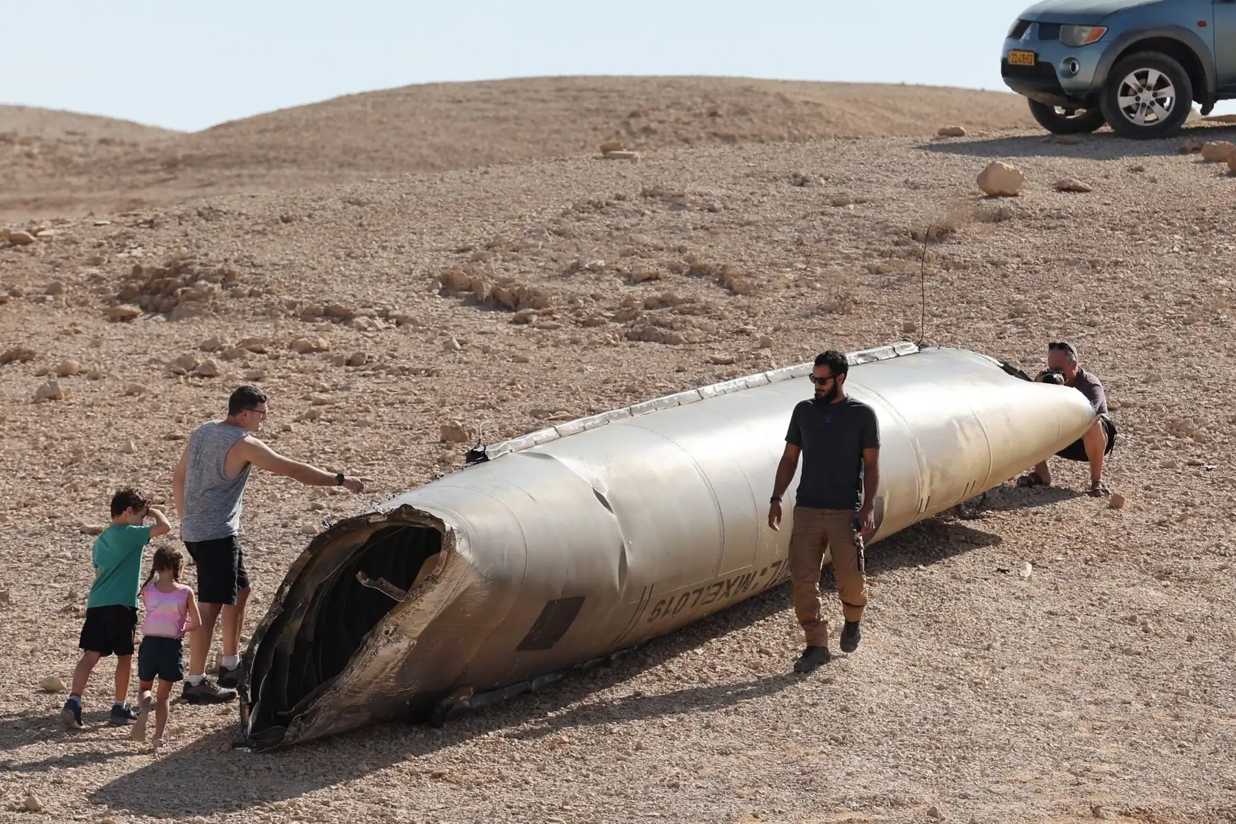 La gente observa los restos de un misil balístico iraní en el desierto de Negev, cerca del Mar Muerto, al sur de Israel. Foto: EFE