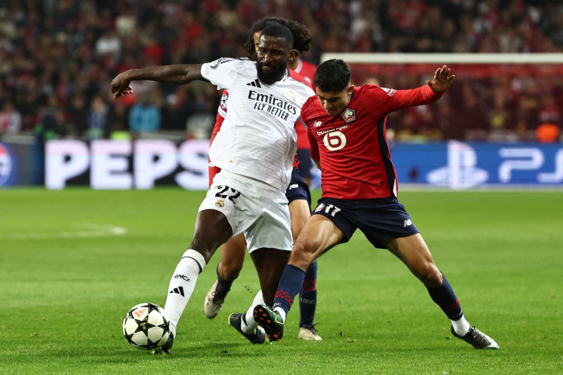 El defensor alemán del Real Madrid, Antonio Ruediger, y el delantero noruego del Lille, Osame Sahraoui, luchan por el balón durante el partido de fútbol de la Liga de Campeones de la UEFA entre Lille LOSC y Real Madrid en el estadio Pierre Mauroy en Francia, el 2 de octubre de 2024. Foto: AFP