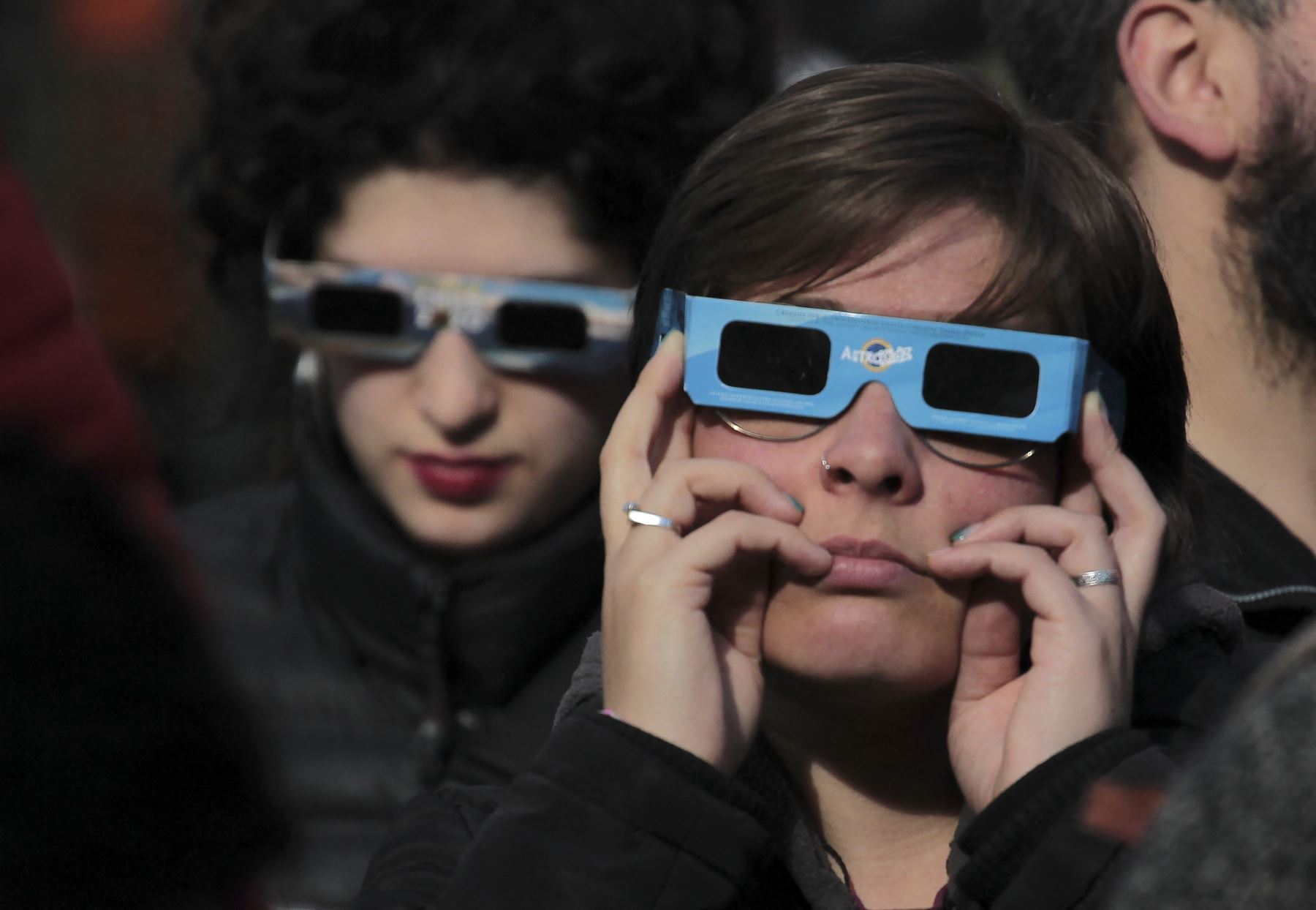 Una mujer usa gafas protectoras para observar el eclipse solar anular en Coyhaique, región de Aysén, Chile. AFP