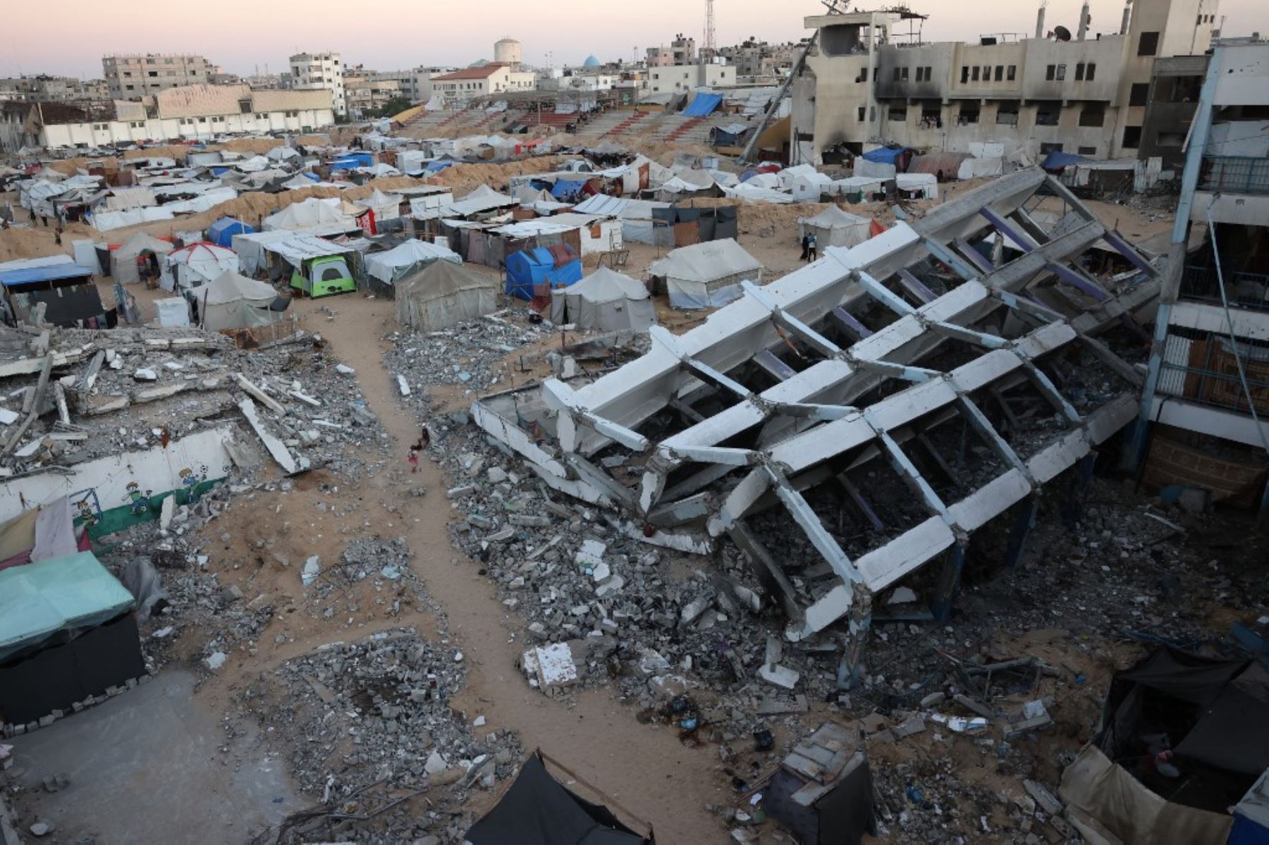 Una niña se encuentra el 17 de septiembre de 2024 en una escuela destruida por los ataques israelíes en Khan Yunis, en el sur de la Franja de Gaza, en medio de la guerra en curso entre Israel y el grupo militante Hamás. Foto: AFP