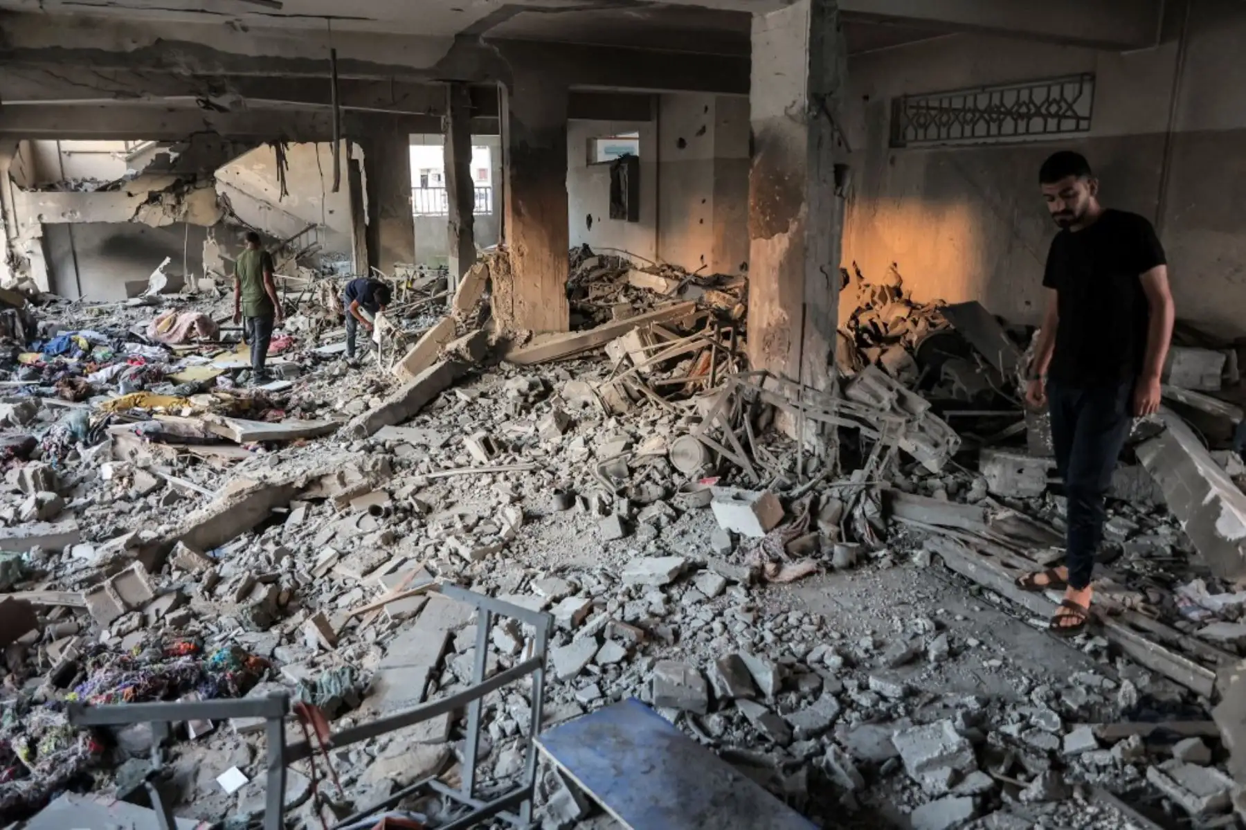 Un grupo de personas inspecciona un aula destruida tras el bombardeo israelí contra la escuela gubernamental palestina de Mascate, financiada con ayuda omaní, en la ciudad de Gaza el 2 de octubre de 2024, en medio de la guerra en el territorio palestino entre Israel y Hamás. Foto: AFP