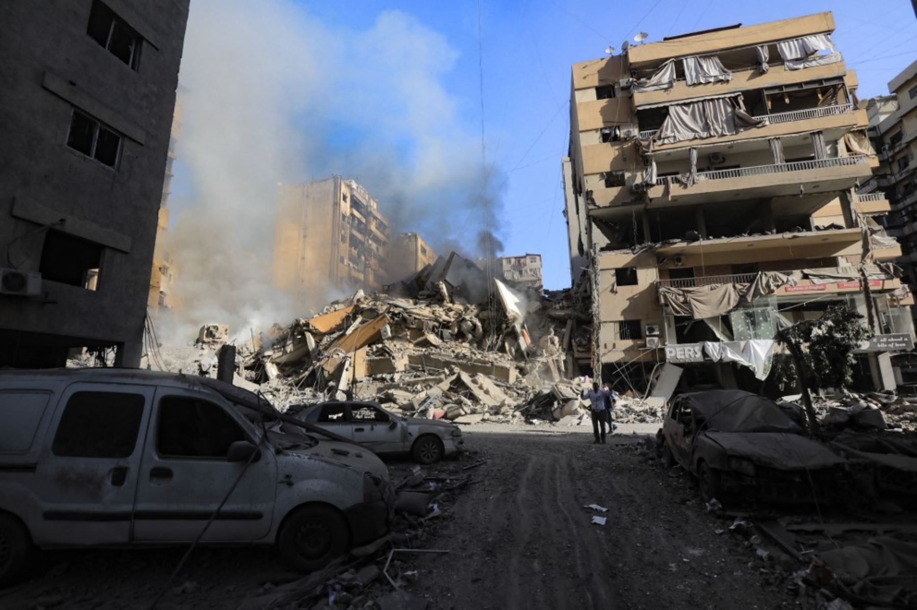 Un residente camina frente a un edificio aún en llamas después de que fuera derribado en un ataque aéreo israelí durante la noche que tuvo como objetivo el barrio de Moawwad, en los suburbios del sur de Beirut, el 3 de octubre de 2024. Foto: AFP