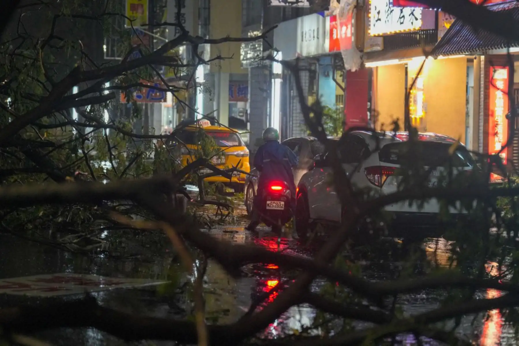 Un conductor de scooter se abre paso entre árboles caídos después de que el tifón Krathon tocara tierra en Kaohsiung. El tifón Krathon azotó Taiwán, provocando deslizamientos de tierra, inundaciones y vientos destructivos en la isla cerrada, donde al menos dos personas han muerto a causa de la tormenta y miles han sido evacuadas. Foto: ANDINA/AFP