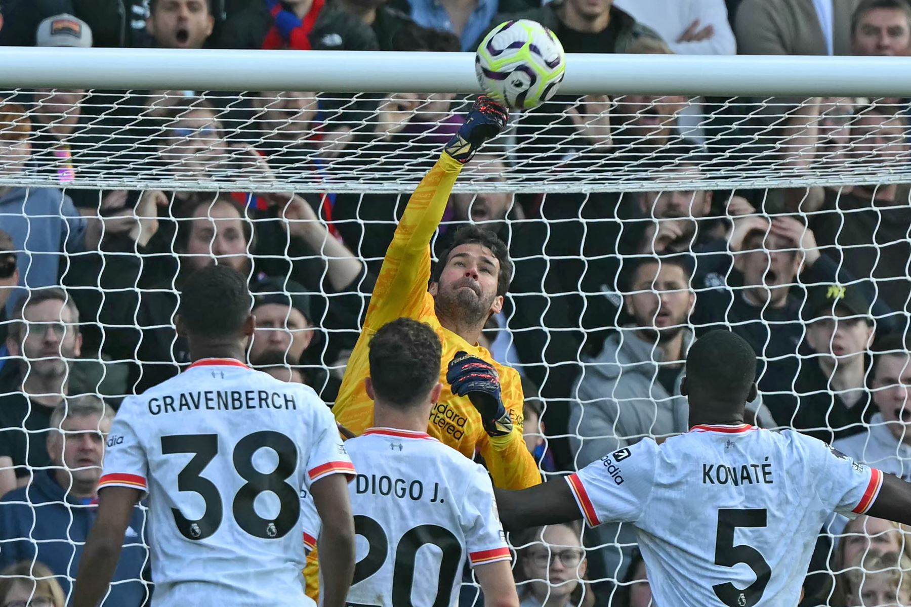 El portero brasileño del Liverpool  Alisson Becker ataja el balón durante el partido de fútbol de la Liga Premier inglesa entre Crystal Palace y Liverpool.  AFP