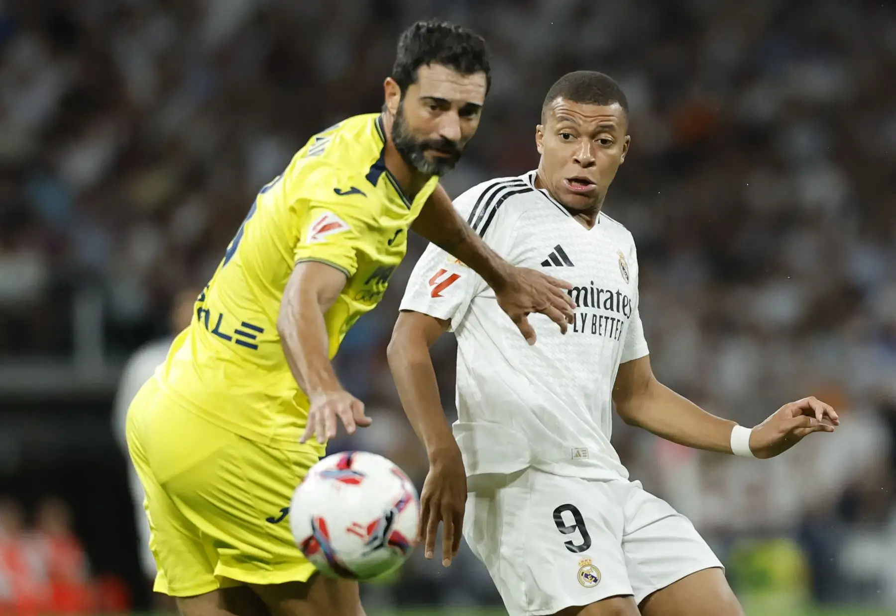 El delantero francés del Real Madrid Kylian Mbappé lucha por el balón con el defensa español del Villarreal Raúl Albiol durante el partido de fútbol de la liga española entre el Real Madrid CF y el Villarreal CF en el estadio Santiago Bernabéu de Madrid. Foto: ANDINA/AFP