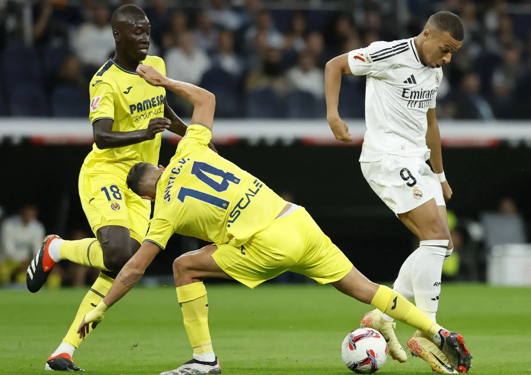 El delantero francés del Real Madrid Kylian Mbappé lucha por el balón con el centrocampista español del Villarreal Santi Comesana durante el partido de fútbol de la liga española entre el Real Madrid CF y el Villarreal CF en el estadio Santiago Bernabéu de Madrid. Foto: ANDINA/AFP