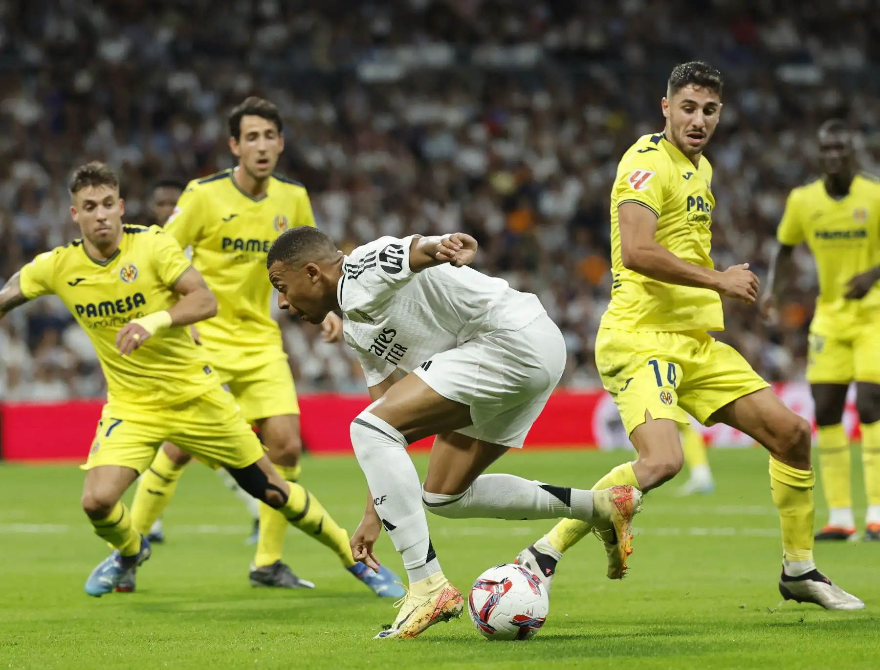 El delantero francés del Real Madrid, Kylian Mbappé, controla el balón durante el partido de fútbol de la liga española entre el Real Madrid CF y el Villarreal CF en el estadio Santiago Bernabéu de Madrid. Foto. ANDINA/AFP