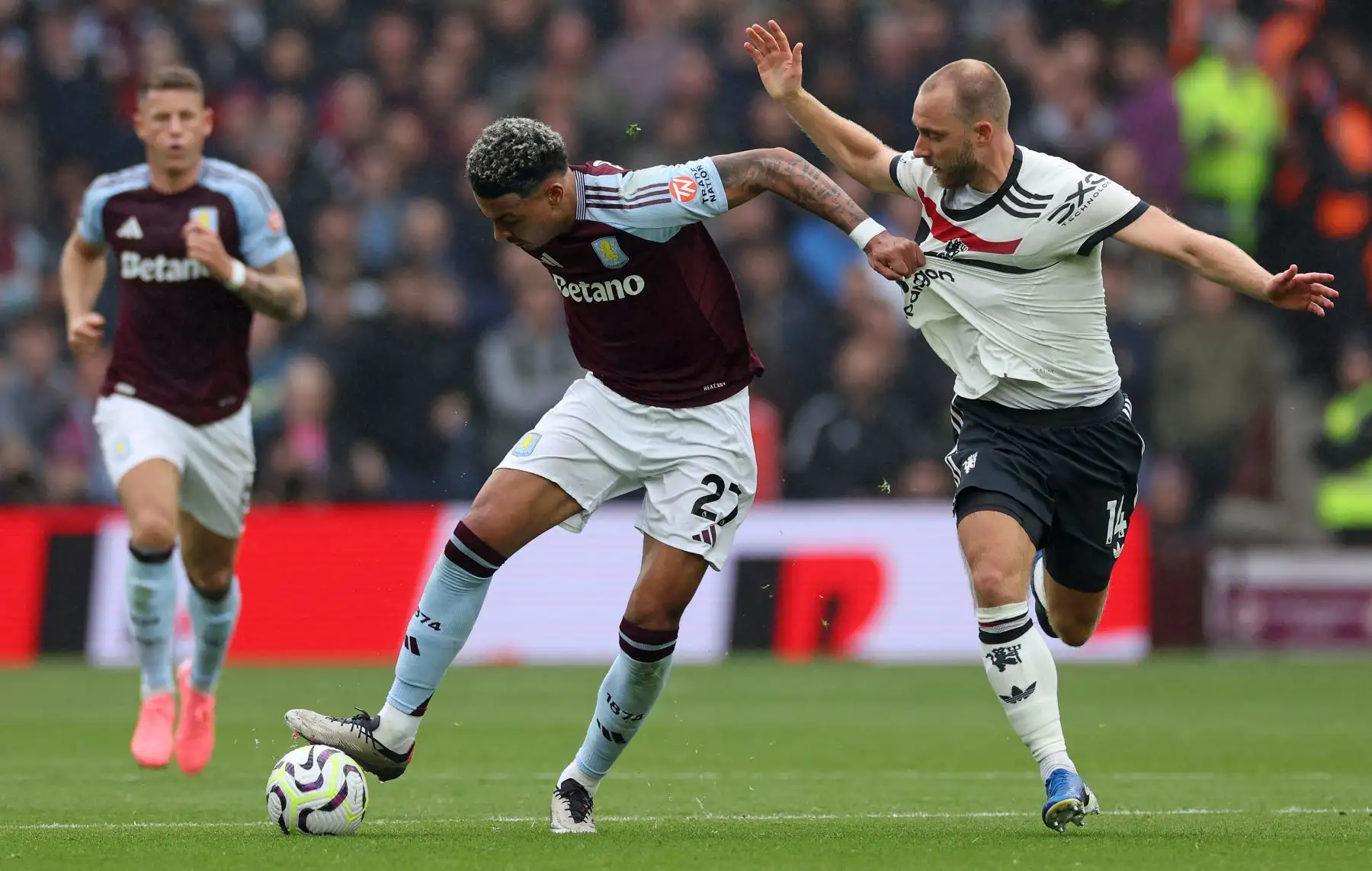 El mediocampista inglés del Aston Villa  Morgan Rogers tira de la camiseta del mediocampista danés del Manchester United Christian Eriksen durante el partido de fútbol de la Premier League inglesa entre el Aston Villa y el Manchester United. AFP