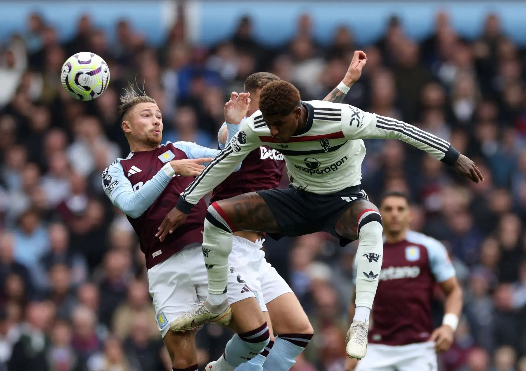 El defensor inglés del Aston Villa  Matty Cash  y el delantero inglés del Manchester United  Marcus Rashford saltan para encabezar el balón durante el partido de fútbol de la Liga Premier inglesa entre el Aston Villa y el Manchester United. AFP