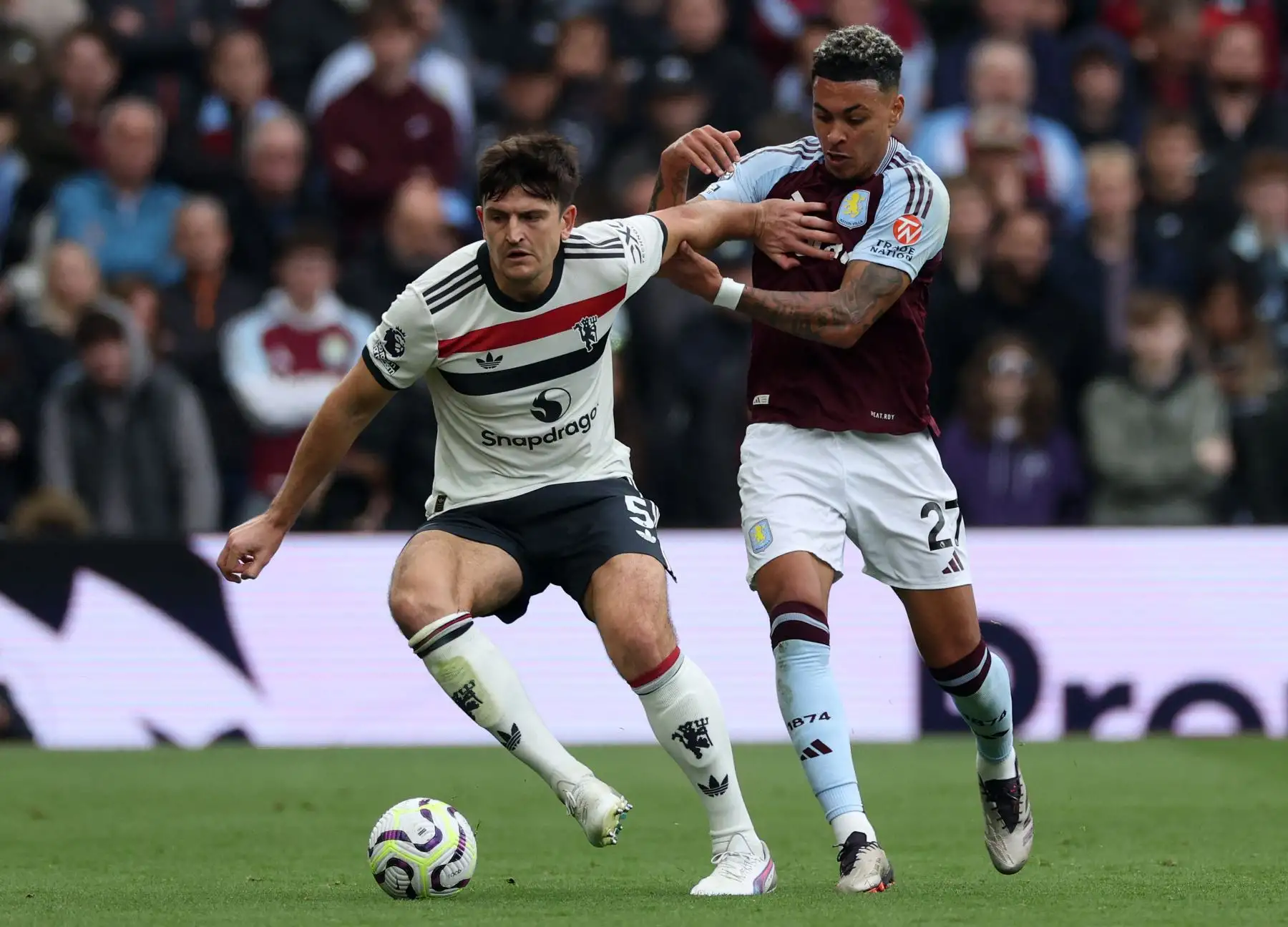 El centrocampista inglés del Aston Villa  Morgan Rogers  compite con el defensor inglés del Manchester United  Harry Maguire durante el partido de fútbol de la Premier League inglesa entre el Aston Villa y el Manchester United. AFP