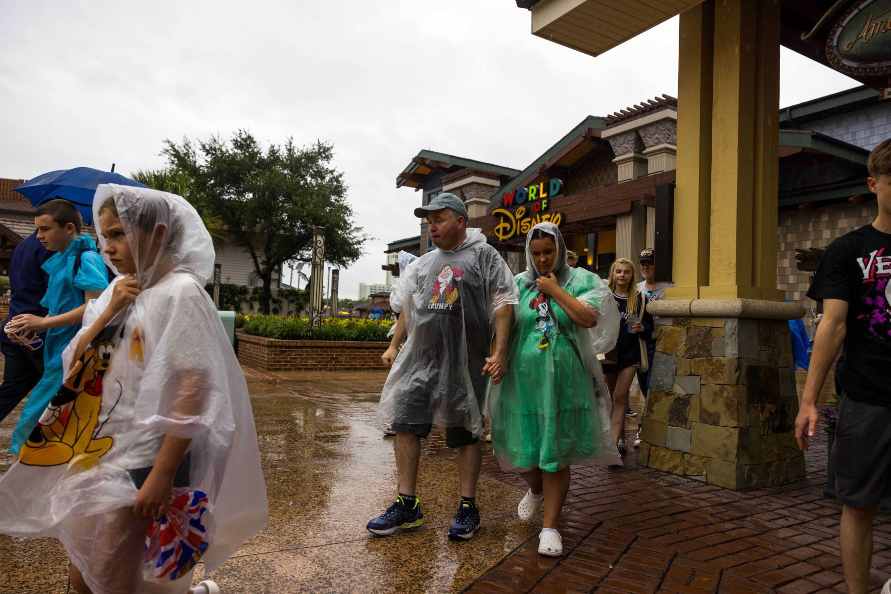 Personas caminando por el complejo comercial de Disney Springs antes del huracán Milton. Foto: AFP