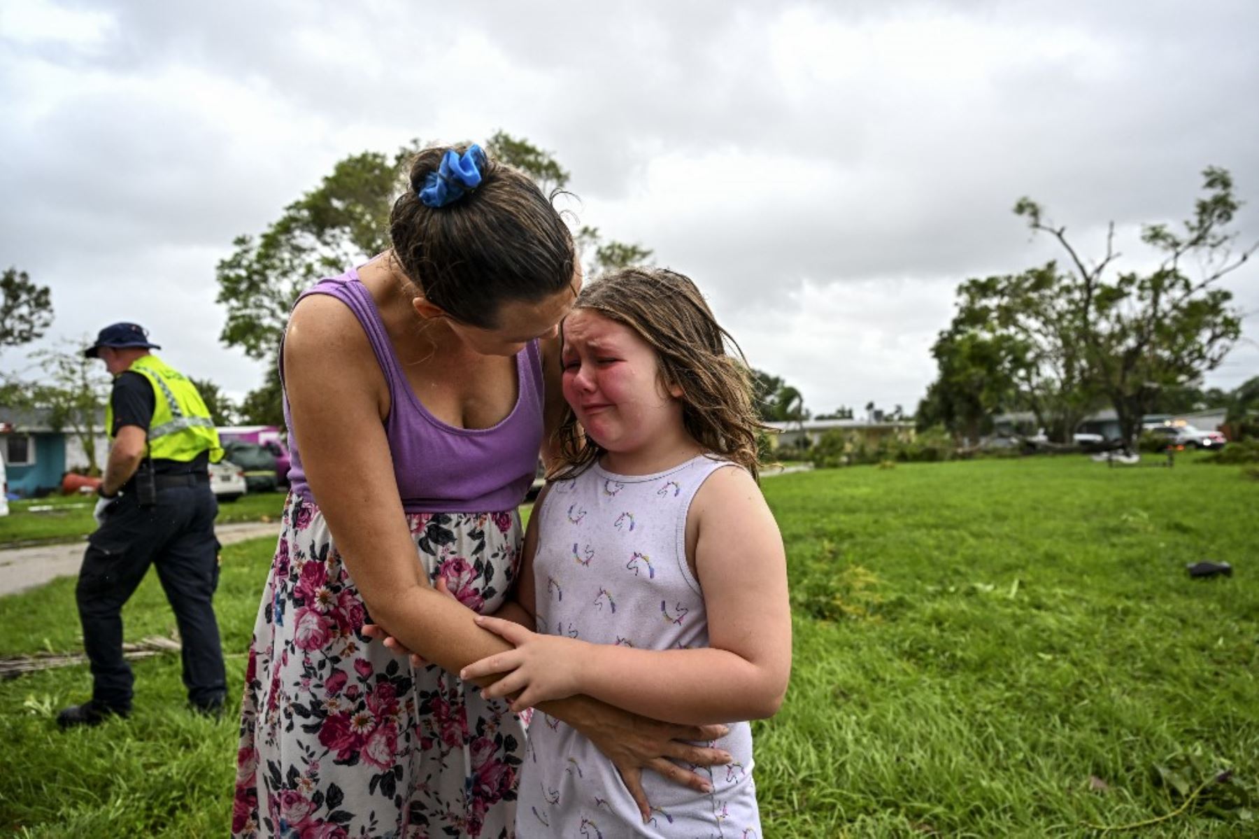 Samantha Dubberly consuela a su hija Alexa Haight mientras los médicos atienden a su abuelo después de que resultó herido por un tornado que azotó su casa en Fort Myers, Florida. Foto: AFP