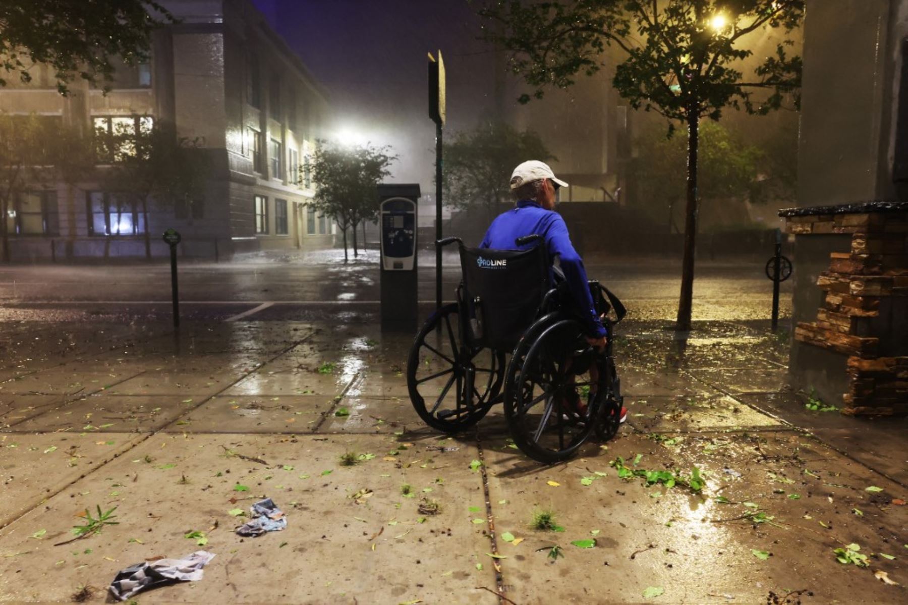 Una mujer en silla de ruedas camina por una acera mientras el huracán Milton toca tierra el 9 de octubre de 2024 en Tampa, Florida, EE.UU. Foto: Getty Images/AFP