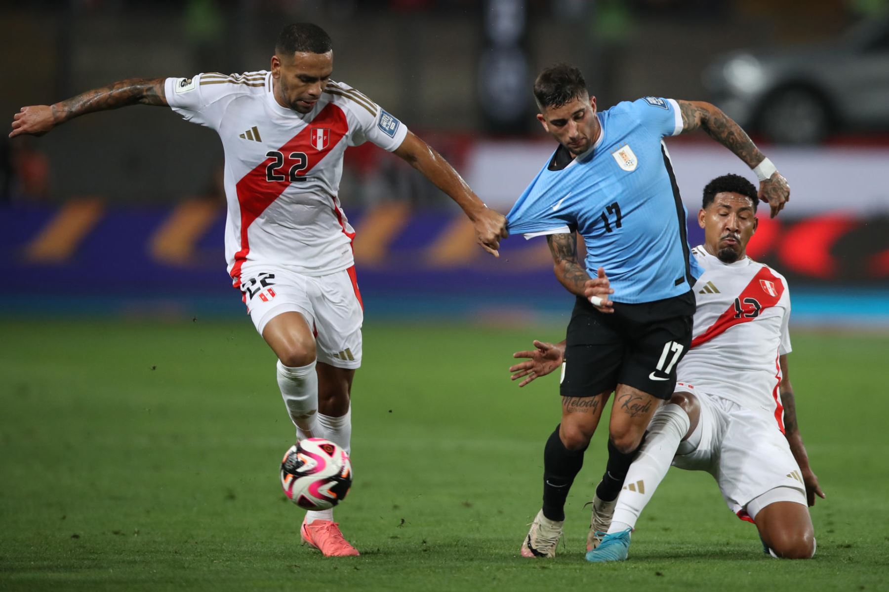 Alexander Callens y Jesús Castillo de Perú disputan el balón con Cristian Olivera de Uruguay 
. Foto: EFE