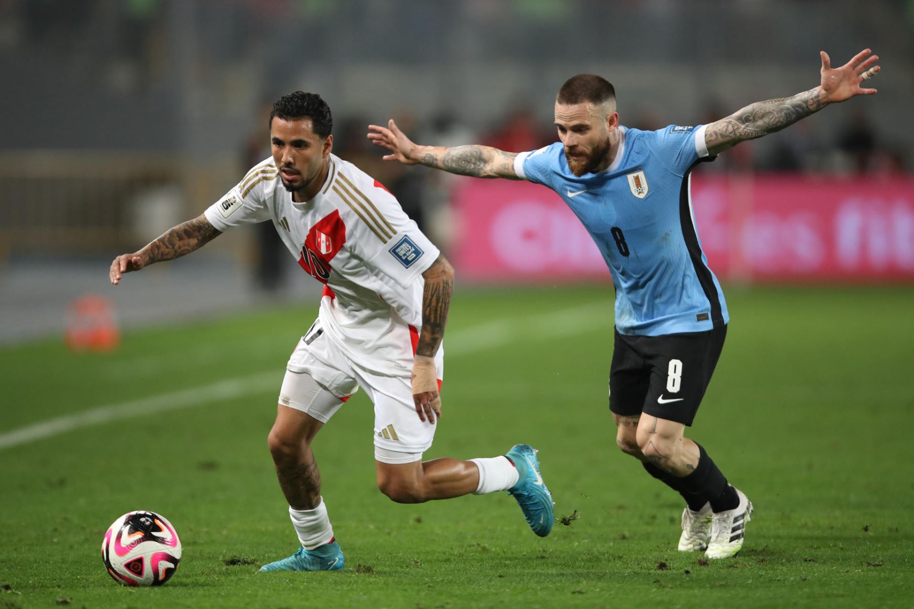 Sergio Peña de Perú disputa el balón con Nahitan Nández de Uruguay.Foto: EFE