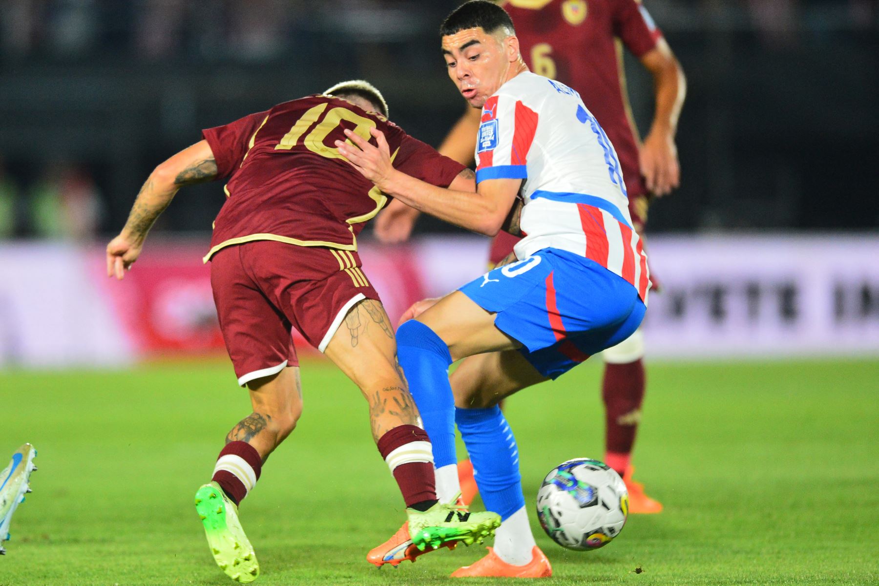 El mediocampista de Venezuela Yeferson Soteldo y el mediocampista de Paraguay Miguel Almirón luchan por el balón durante el partido de fútbol de las eliminatorias sudamericanas para la Copa Mundial de la FIFA 2026 entre Paraguay y Venezuela. AFP