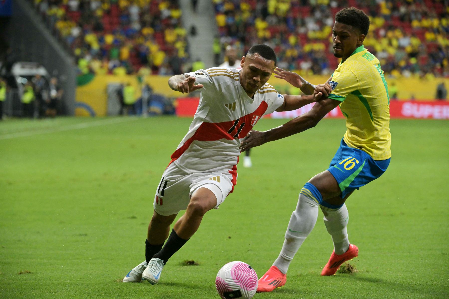 El delantero peruano  Bryan Reyna y el defensor brasileño Abner luchan por el balón durante el partido de fútbol clasificatorio sudamericano para la Copa Mundial de la FIFA 2026 entre Brasil y Perú. AFP