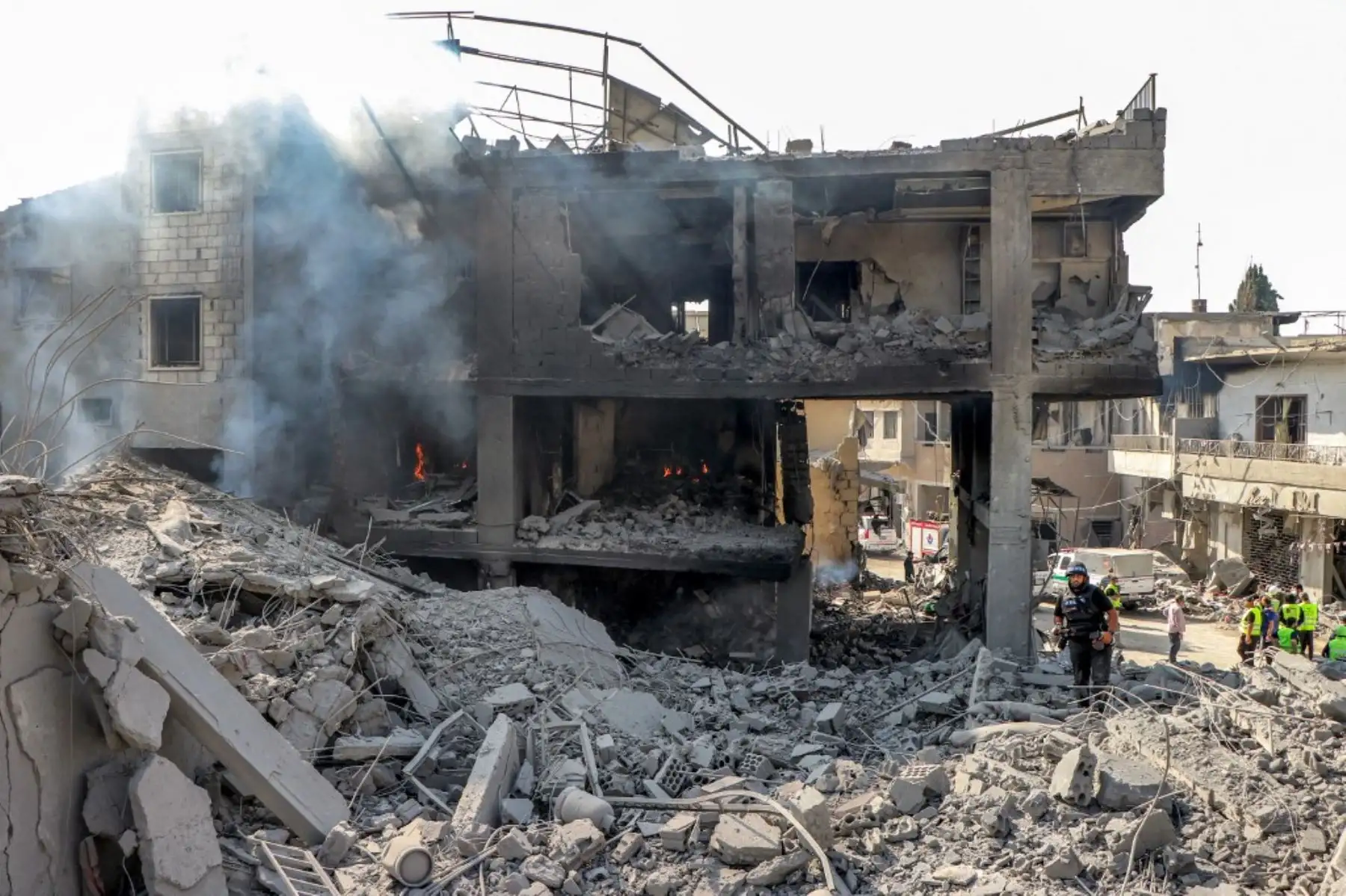Miembros de la defensa civil buscan sobrevivientes entre los escombros de un edificio destruido en el lugar de un ataque aéreo israelí nocturno contra la aldea de Qana, en el sur del Líbano, el 16 de octubre de 2024. Foto: AFP