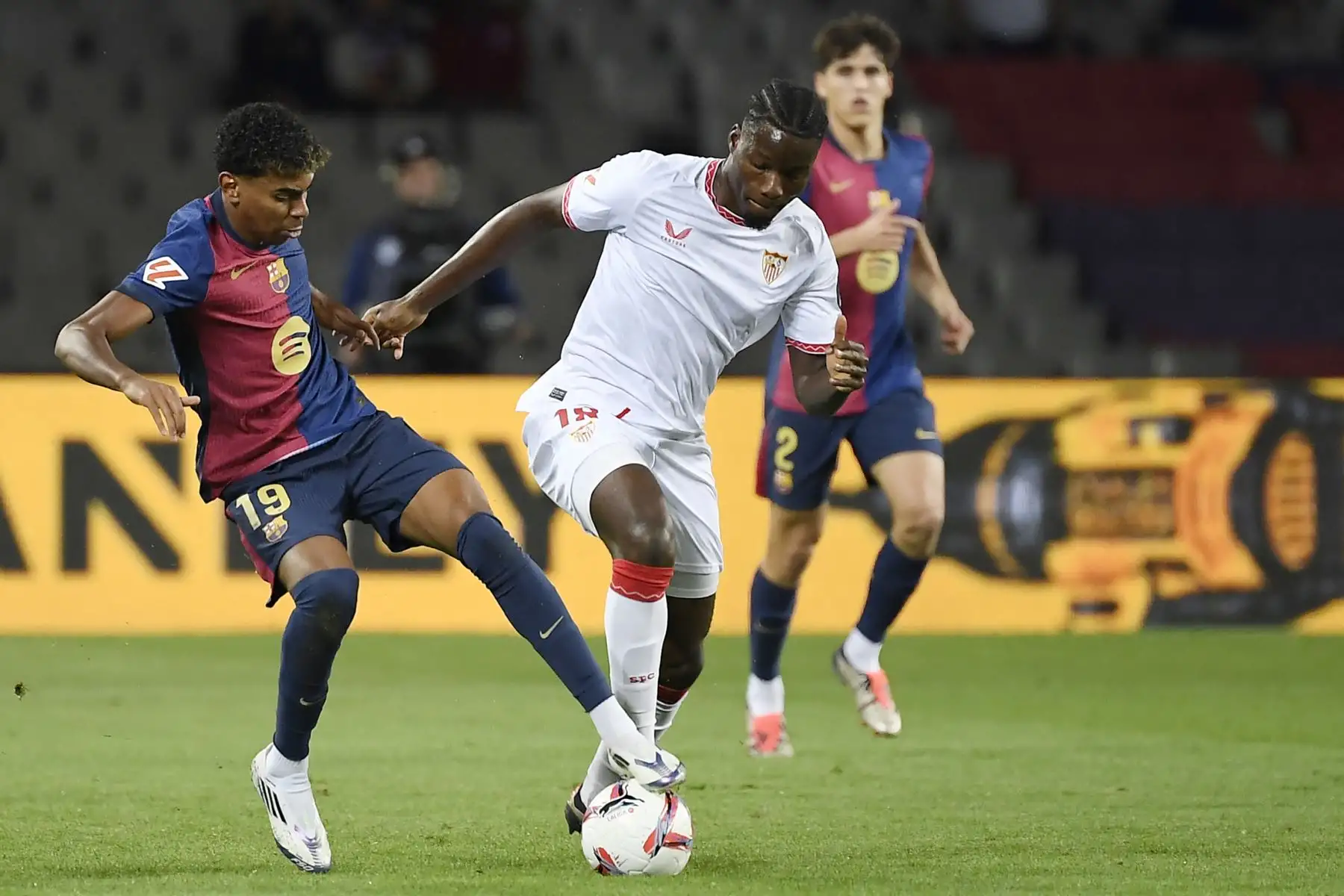 El delantero español del Barcelona Lamine Yamal y el centrocampista francés del Sevilla Lucien Agoume compiten por el balón durante el partido de fútbol de la liga española entre el FC Barcelona y el Sevilla FC en el Estadi Olimpic Lluis Companys en Barcelona. Foto: ANDINA/AFP