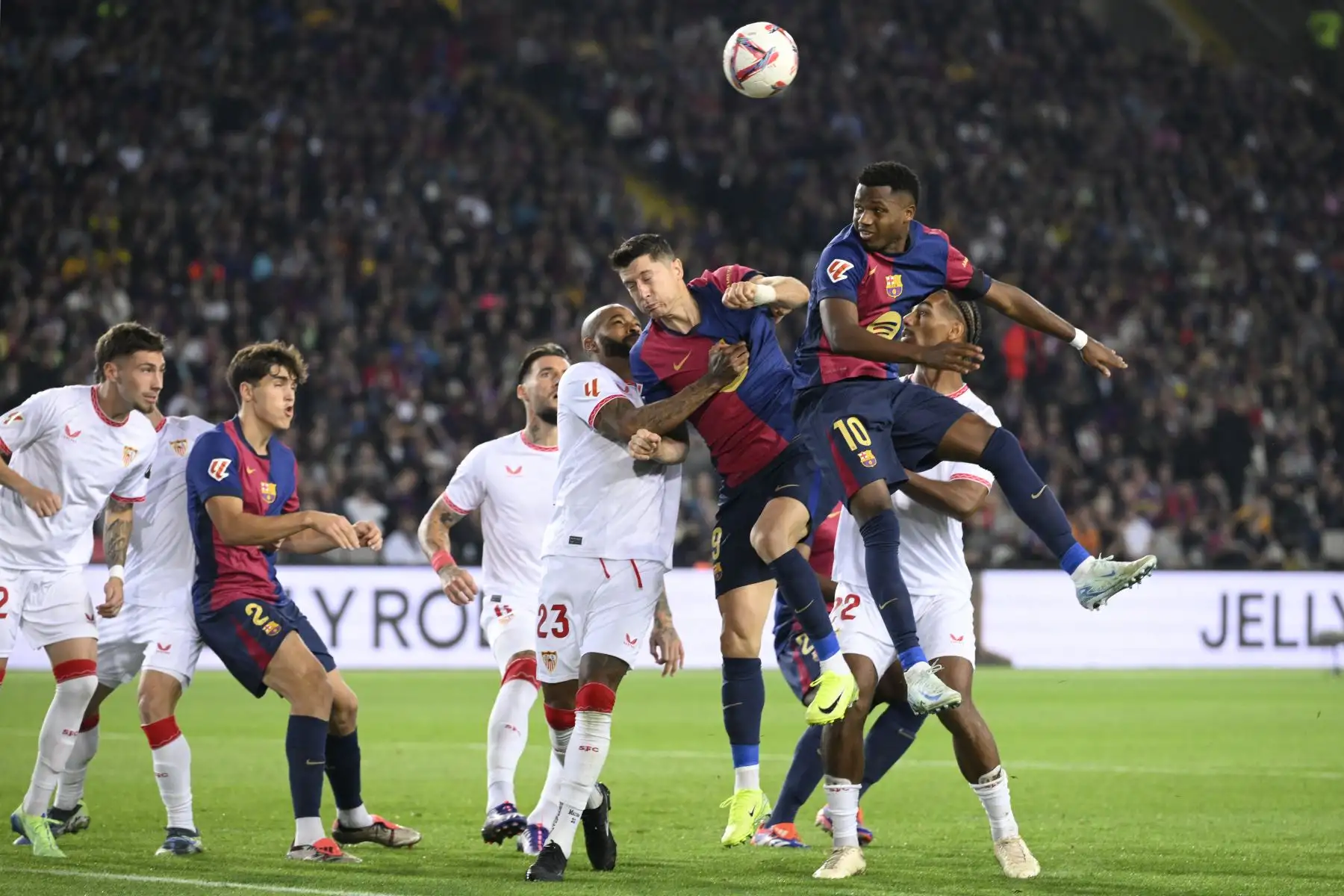 El defensa brasileño del Sevilla, Marcao Teixeira, el delantero polaco del Barcelona, ​​Robert Lewandowski, y el delantero español del Barcelona, ​​Ansu Fati, compiten por un cabezazo durante el partido de fútbol de la liga española entre el FC Barcelona y el Sevilla FC en el Estadi Olimpic Lluis Companys en Barcelona. Foto: ANDINA/AFP