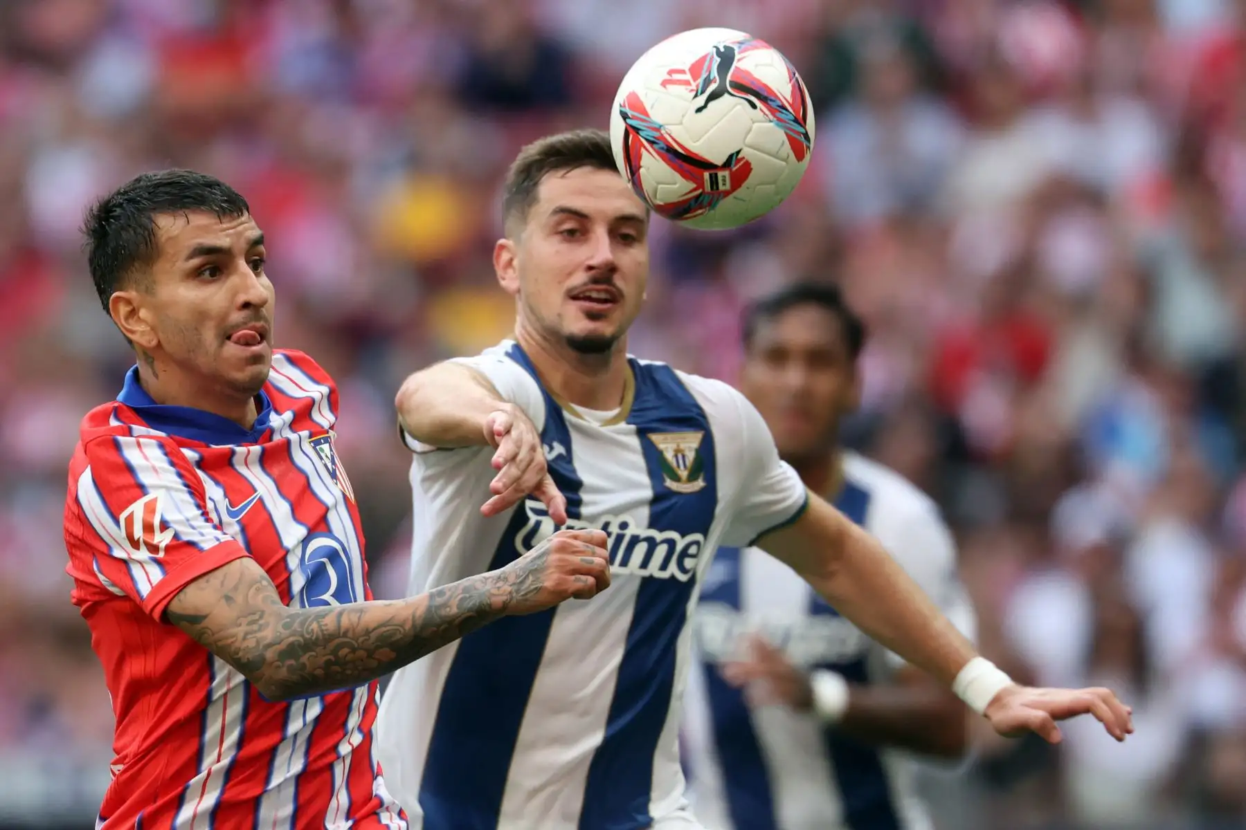 El delantero argentino del Atlético de Madrid, Ángel Correa, y el defensa español del Leganés, Javi Hernández, compiten por el balón durante el partido de fútbol de la liga española entre el Club Atlético de Madrid y el Club Deportivo Leganés SAD en el estadio Metropolitano de Madrid. Foto: ANDINA/AFP