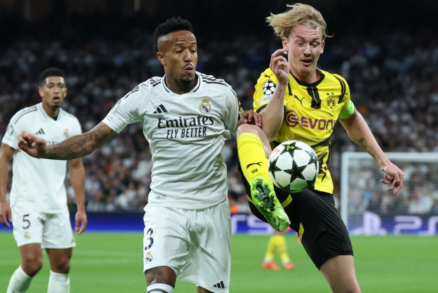 El defensor brasileño del Real Madrid, Eder Militao, lucha por el balón con el mediocampista alemán del Borussia Dortmund, Julian Brandt, durante el partido de fútbol de la Liga de Campeones de la UEFA, fase de liga, entre el Real Madrid CF y el Borussia Dortmund en el estadio Santiago Bernabeu de Madrid el 22 de octubre de 2024. Foto: AFP