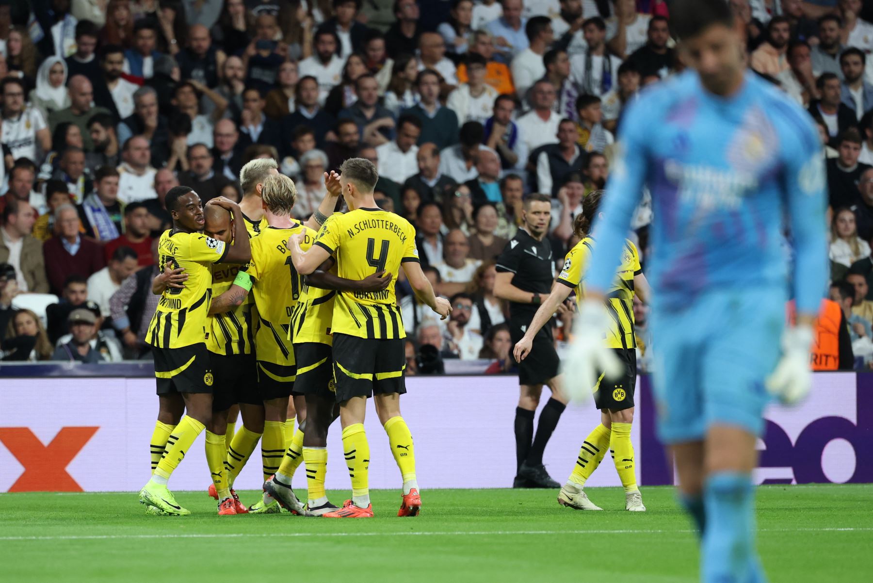 El delantero holandés del Borussia Dortmund  Donyell Malen celebra con sus compañeros de equipo tras marcar su primer gol durante el partido de fútbol del día 3 de la Liga de Campeones de la UEFA, fase liguera, entre el Real Madrid CF y el Borussia Dortmund. AFP