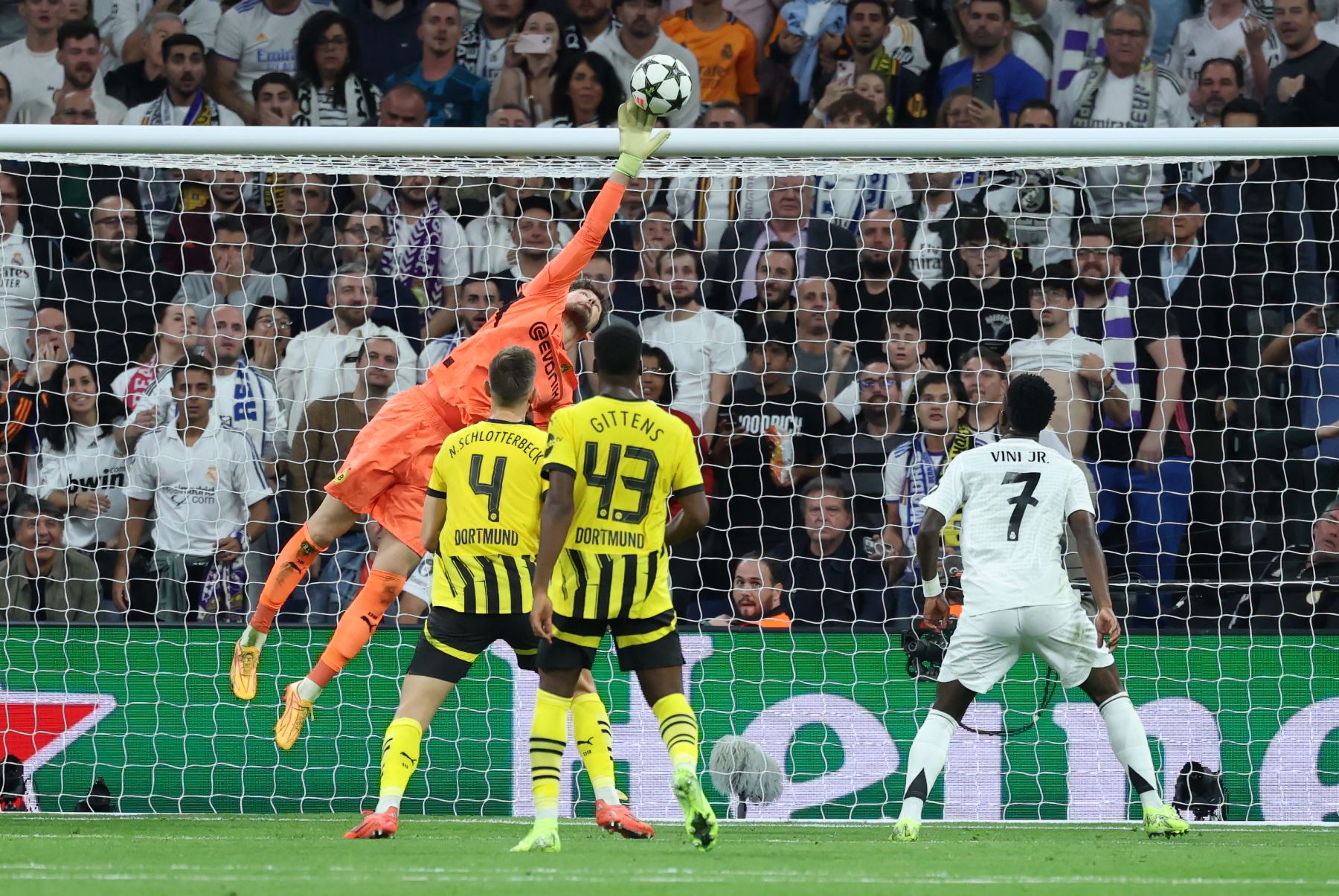 El portero suizo del Borussia Dortmund  Gregory Kobel alcanza un balón mientras el delantero brasileño del Real Madrid  Vinicius Junior mira durante la Liga de Campeones de la UEFA, fase de liga del día 3 del partido de fútbol entre el Real Madrid CF y el Borussia Dortmund. AFP