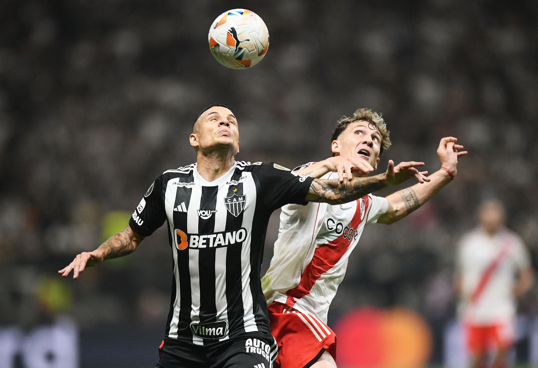 El defensor del Atlético Mineiro  Guilherme Arana y el delantero del River Plate  Facundo Colidio luchan por el balón durante el partido de fútbol de ida de la semifinal de la Copa Libertadores entre el Atlético Mineiro de Brasil y el River Plate de Argentina. AFP